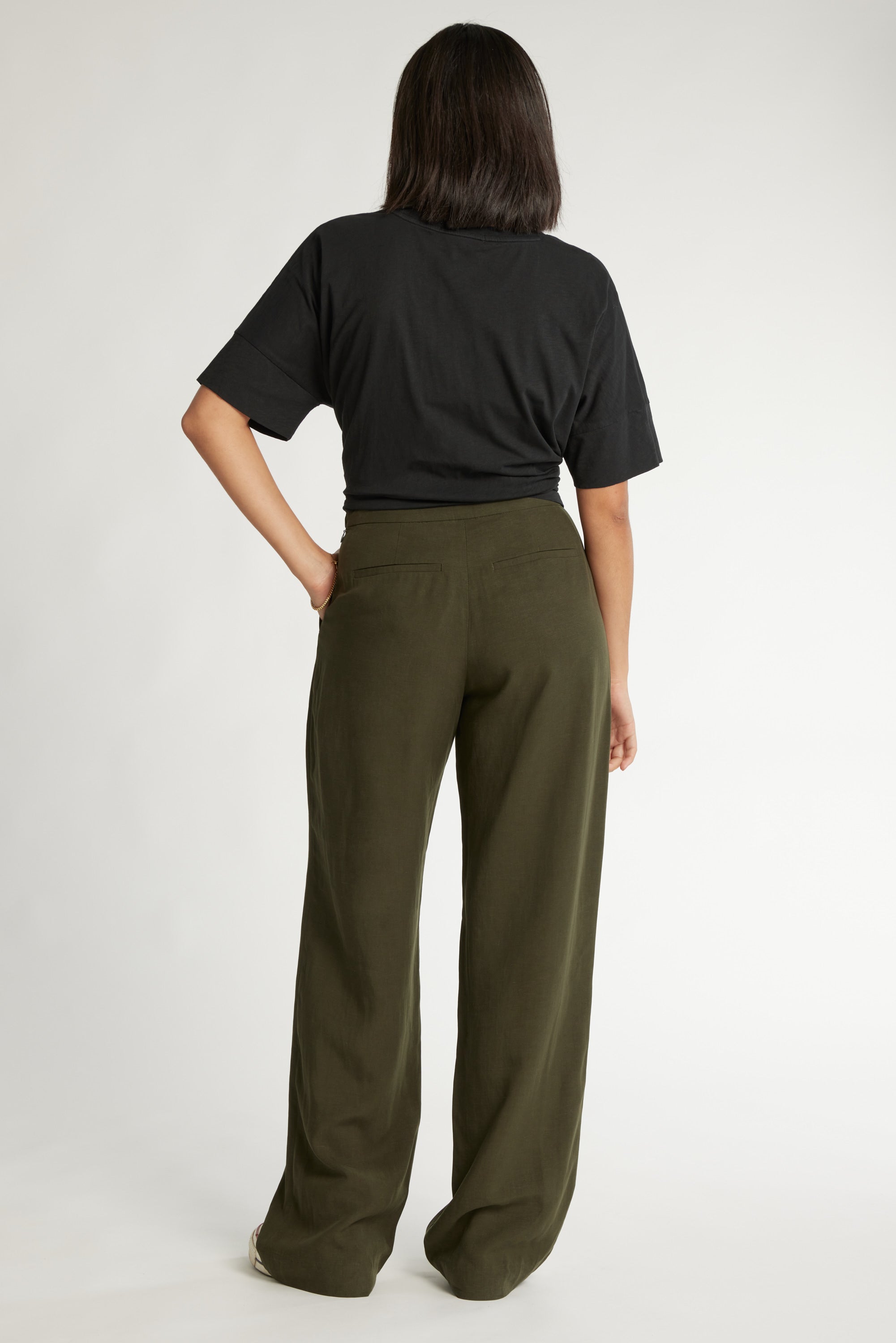 Person in black tee and Max's The Ultimate Wide Leg Pants, standing with back to camera.