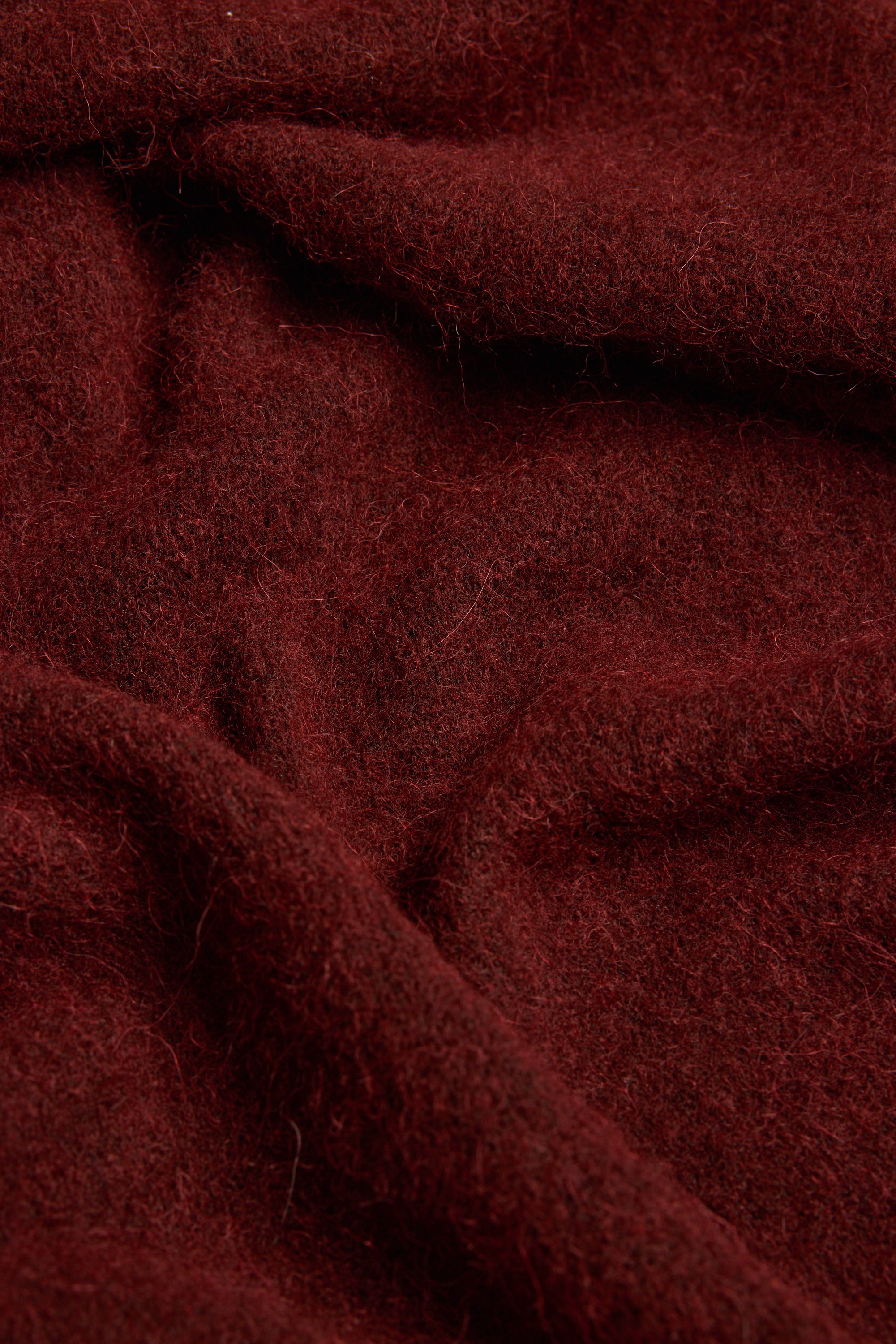 Close-up of Max Hailey Luxe Whisper Knit Scarf in dark red, showing soft texture and gentle folds.