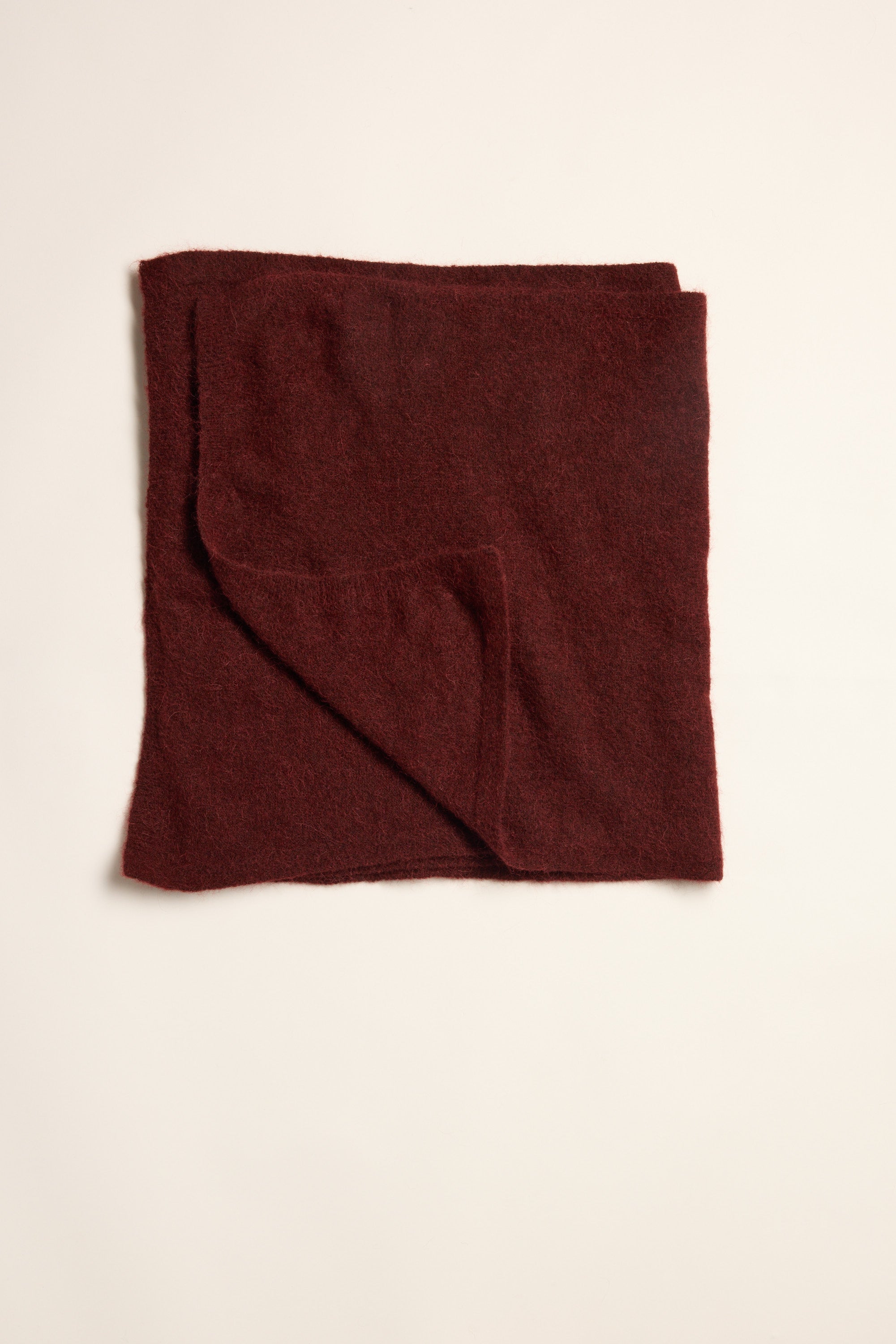 A folded Hailey Luxe Whisper Knit Scarf in dark red by Max on a plain light background.