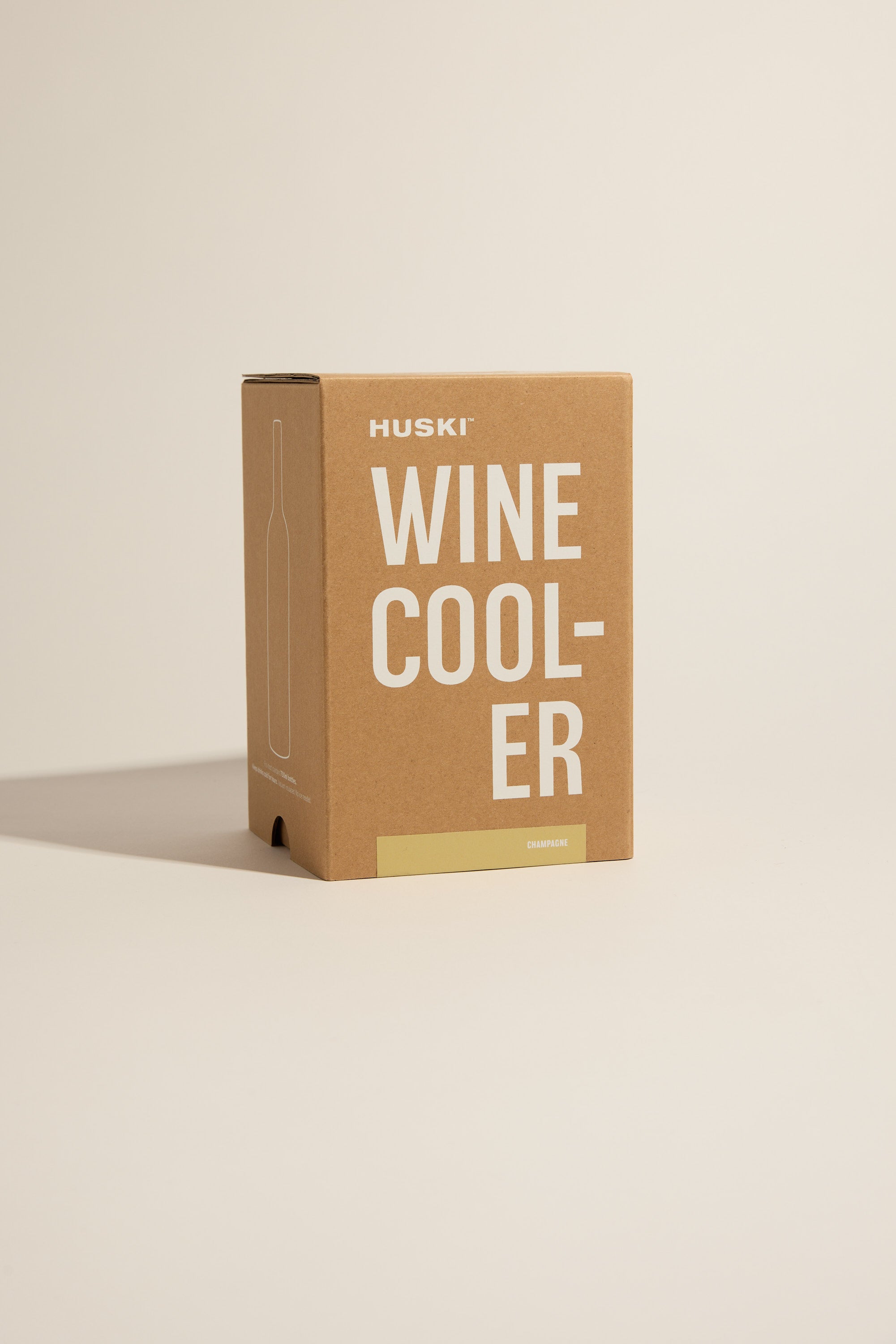 A Huski Wine Cooler box stands upright on a neutral background, showing minimal text and graphics, with an outlined bottle and a small beige CHAMPAGNE label—ideal packaging for your Huski stainless steel wine cooler.