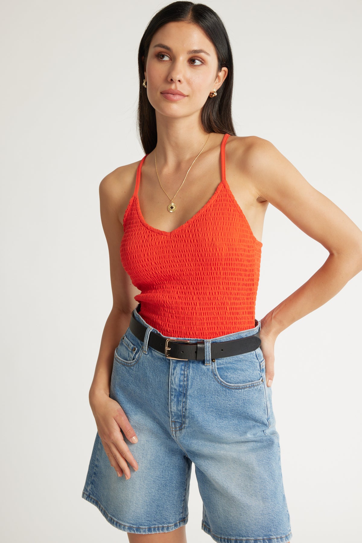 Woman wears Max Madeline Pima Cotton Shirred Cami and denim shorts with a black belt, posing.