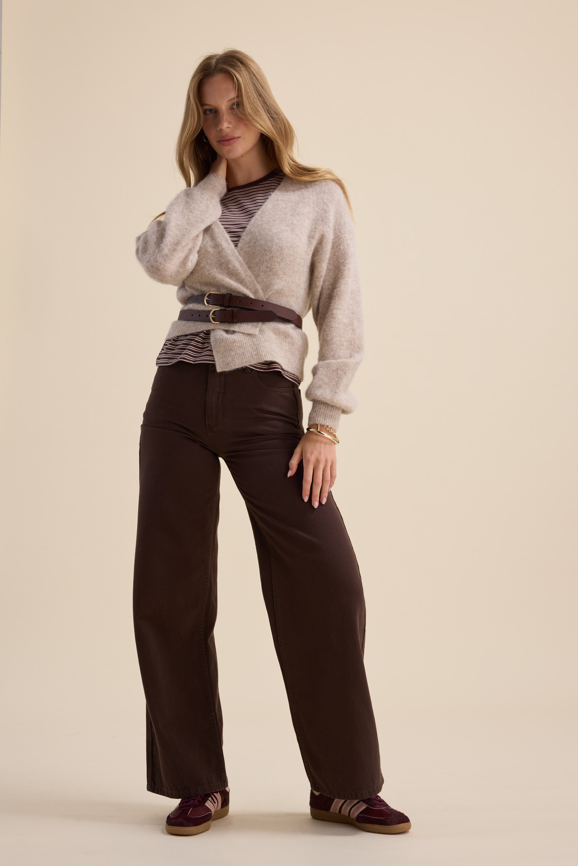 Woman in The Ultimate Luxe Cardigan by Max, with striped top, wide-leg pants, and sneakers.