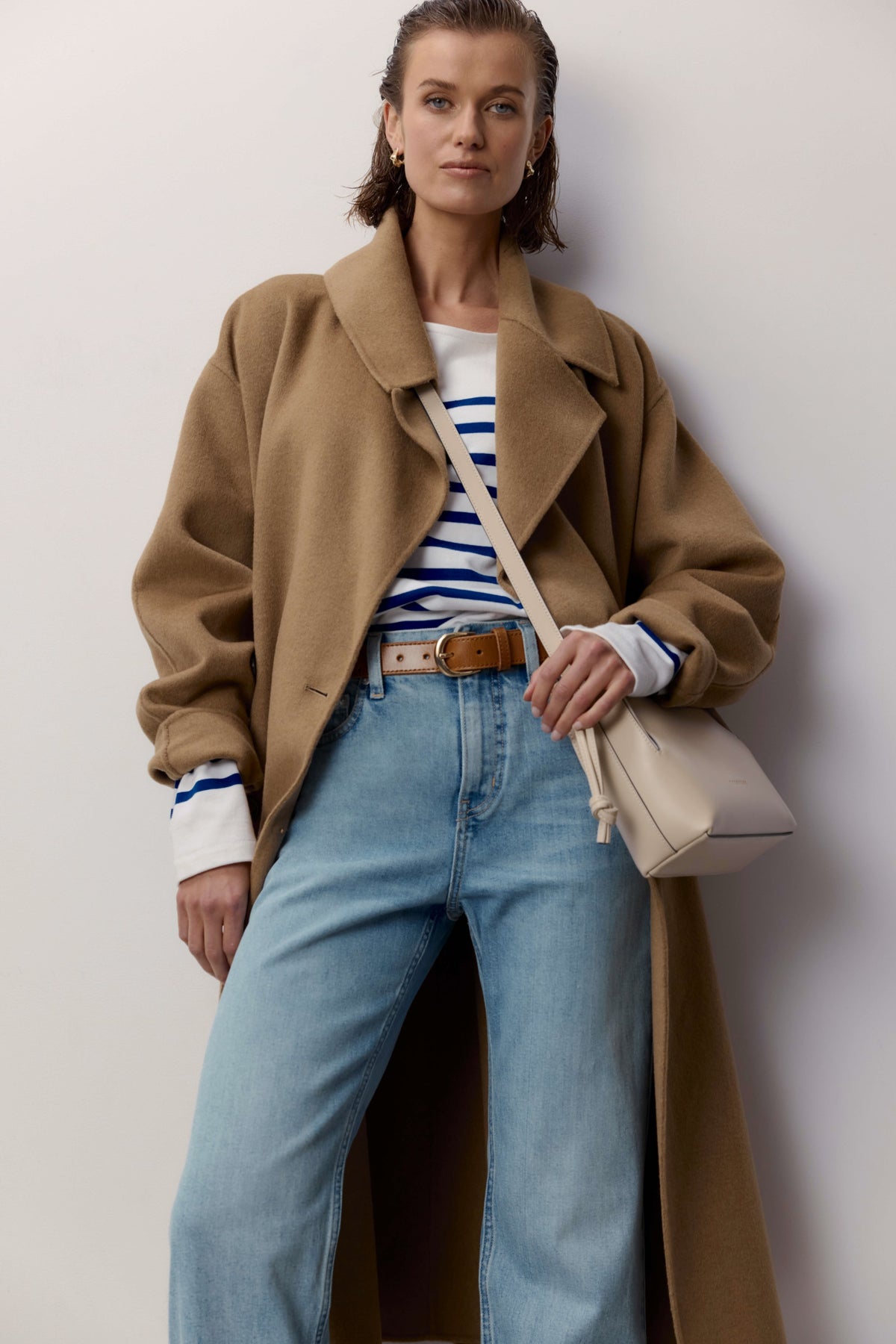 Woman in camel coat, striped shirt, Max Arizona Straight Jeans, with cream crossbody bag.
