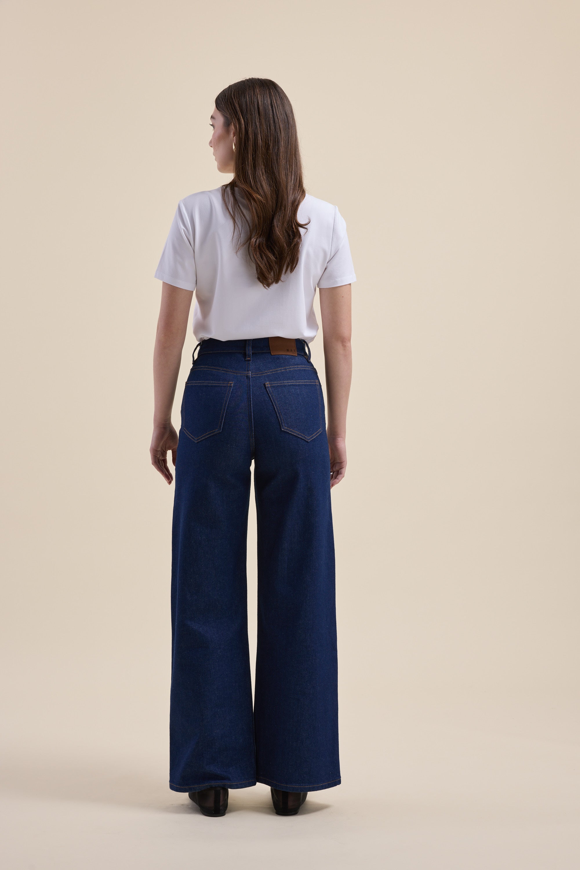 Woman in a white tee and Max Nevada Wide Jeans, back facing the camera.