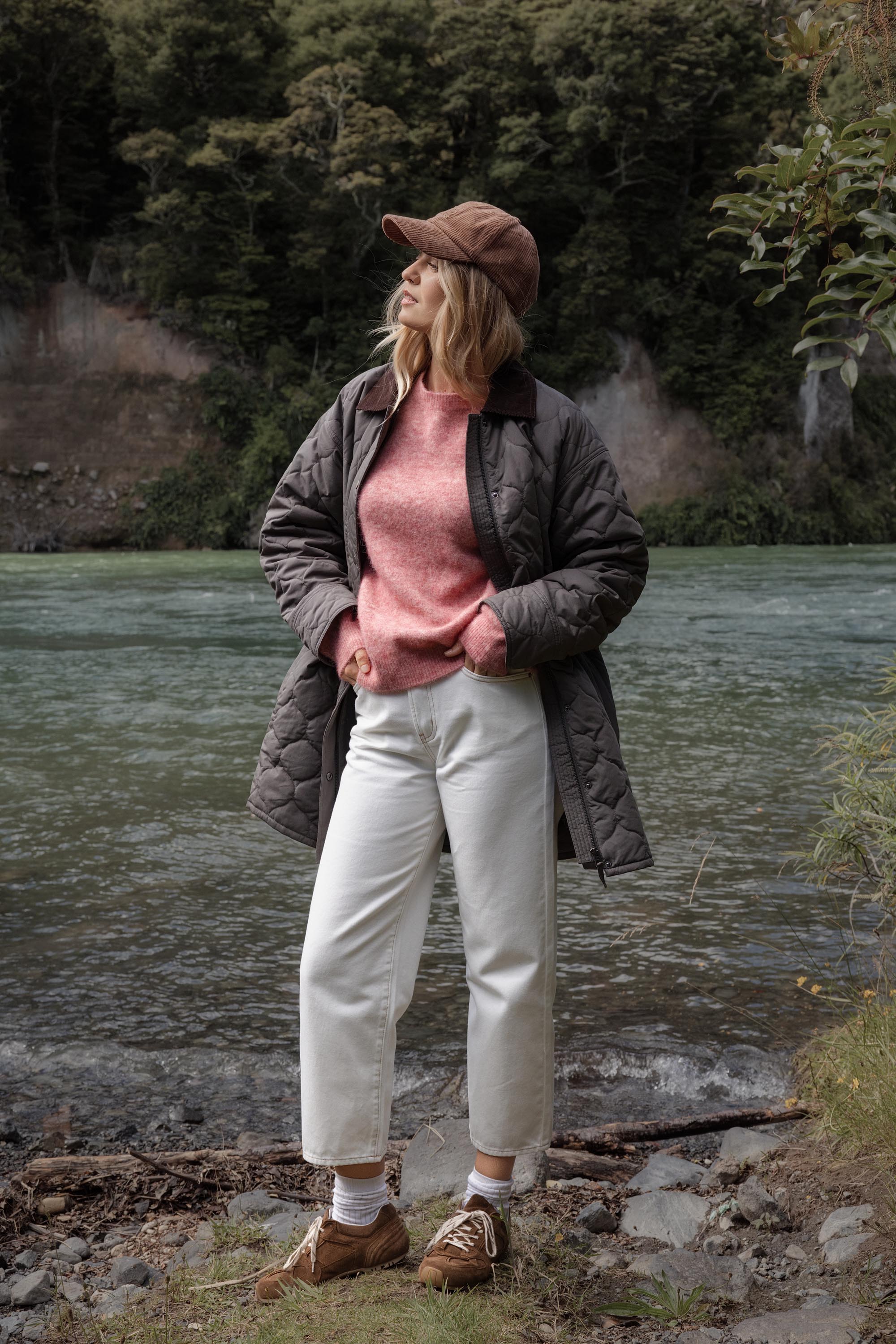 Woman in a Max Hayley Luxe Whisper Crew Neck Sweater stands by a river with trees behind her.