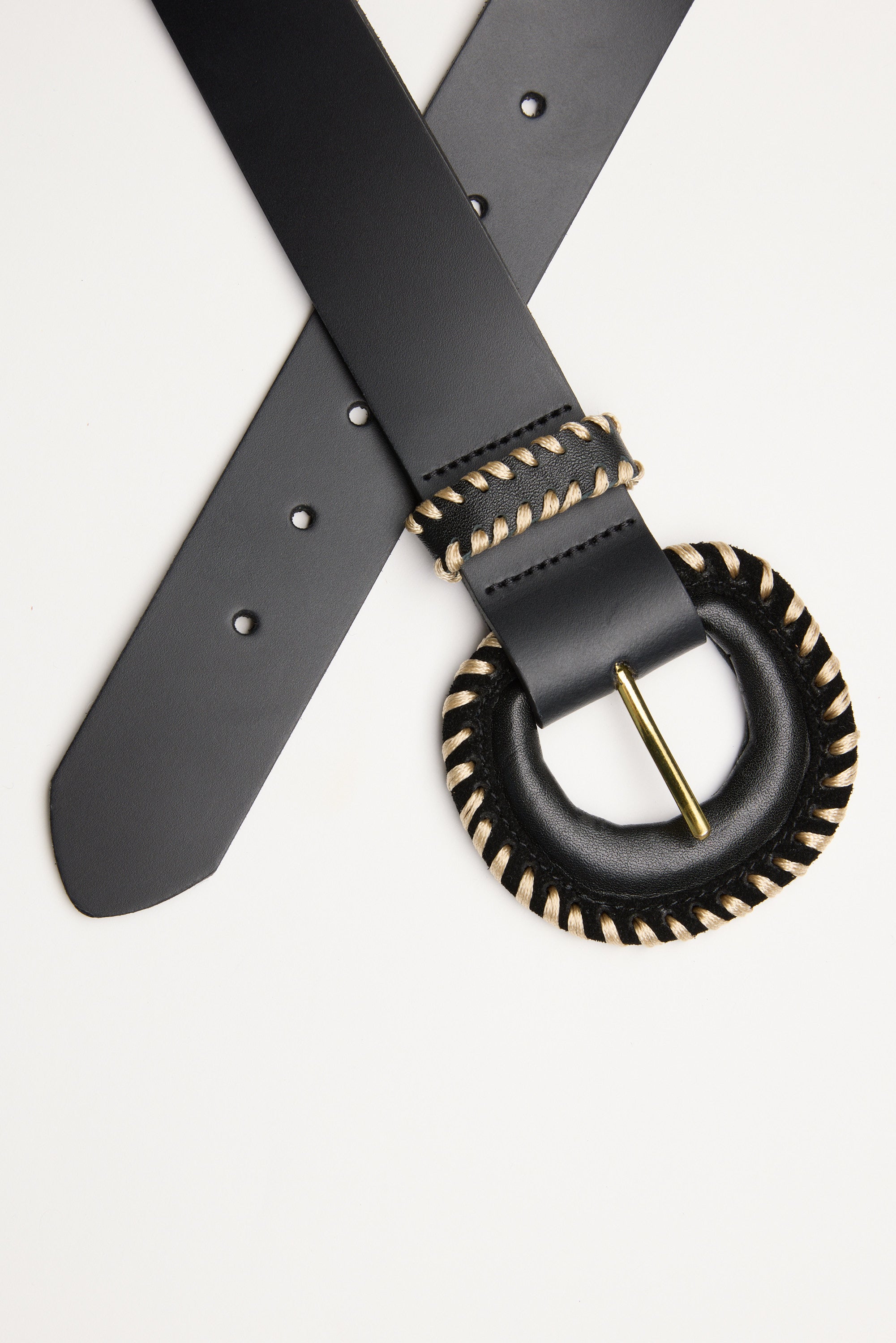 The Contrast Stitch Belt by Max features black leather and a round black buckle with beige stitching, shown on a white background. The belt is crossed buckle-up—a stylish pick for those wanting distinctive, New Zealand-made belts.