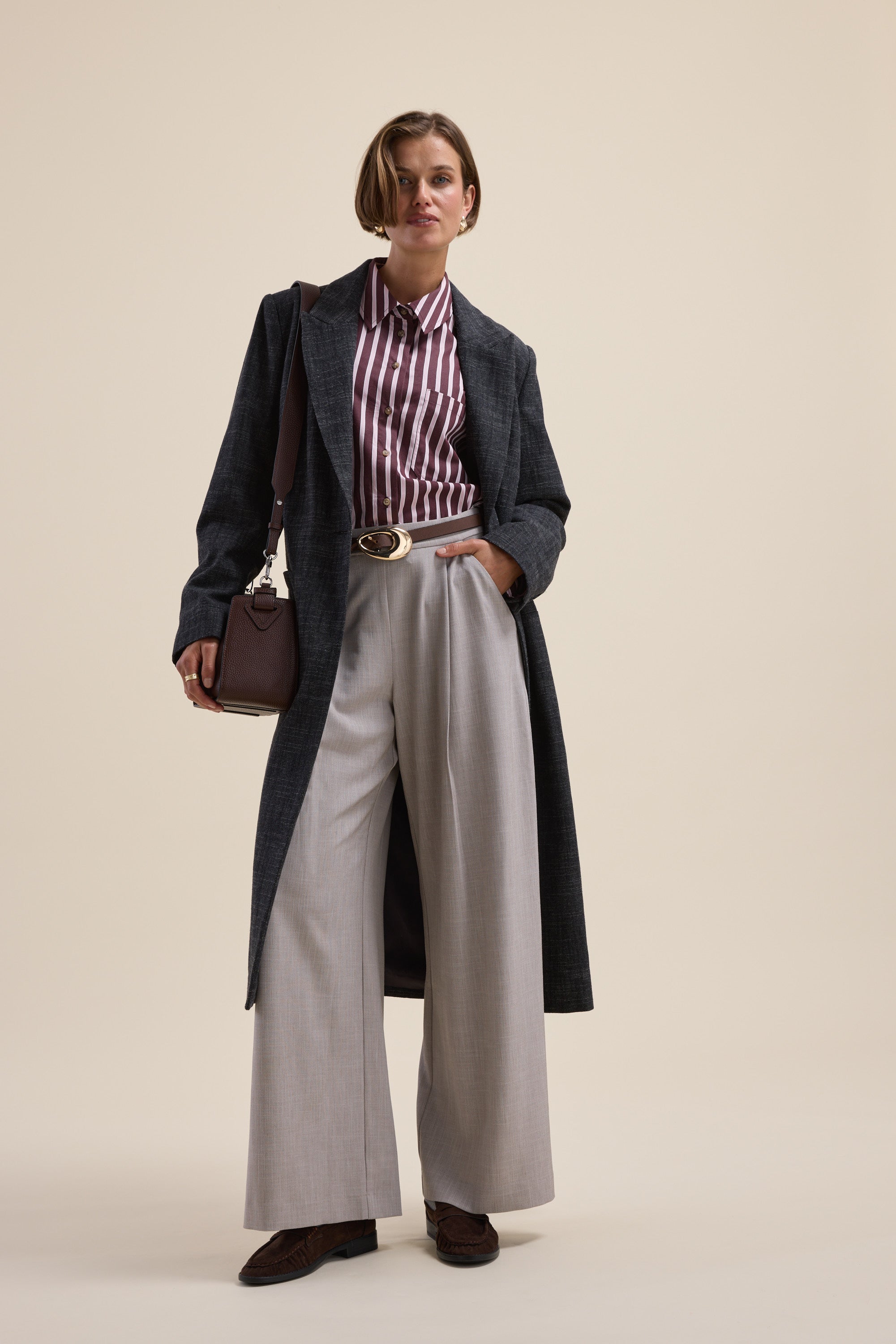Person wearing a Max Leah Stripe Detail Shirt, long dark coat, wide-leg trousers, and a handbag.