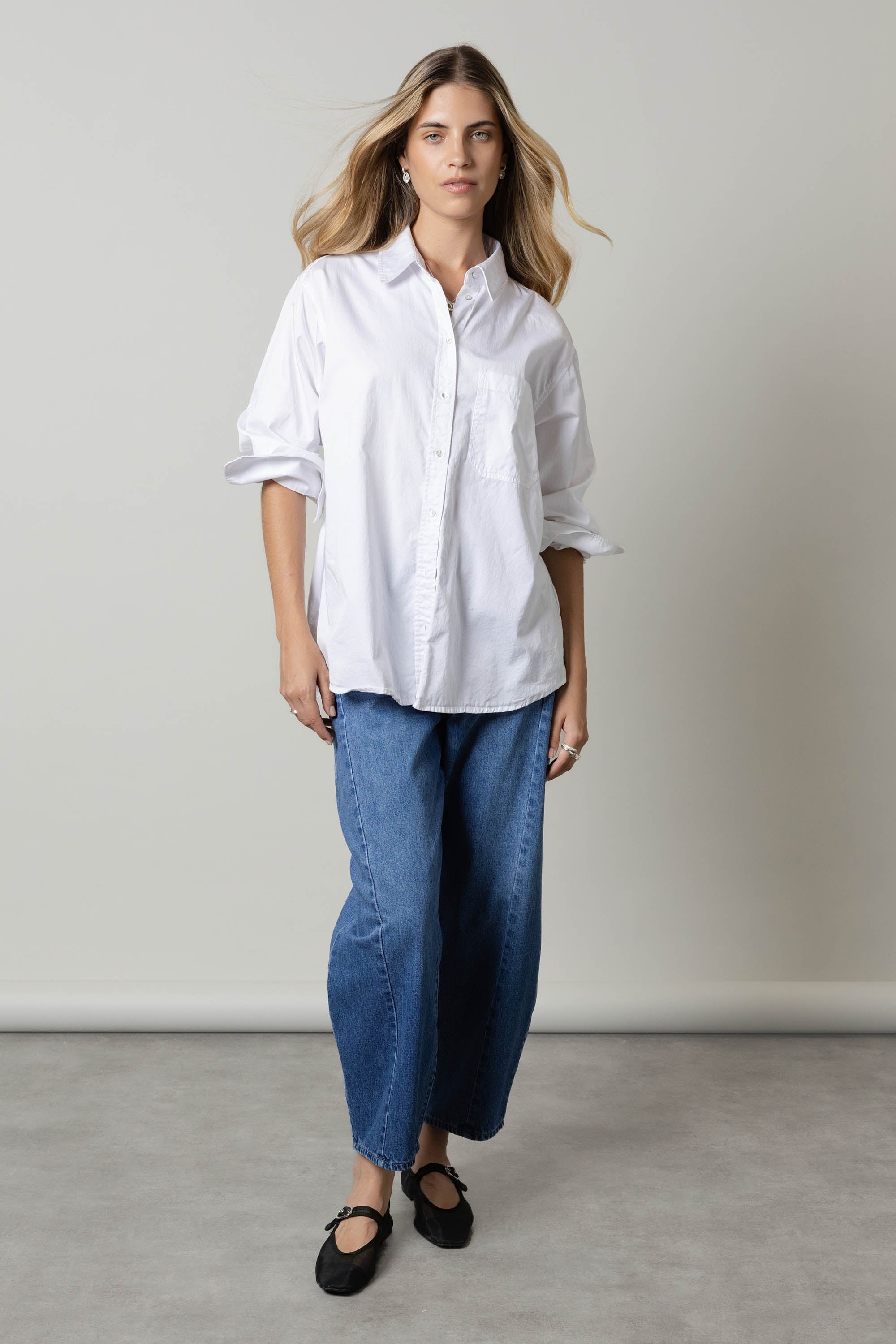 Woman in a white button-up and Max Montreal Barrel Leg Jeans, standing indoors.