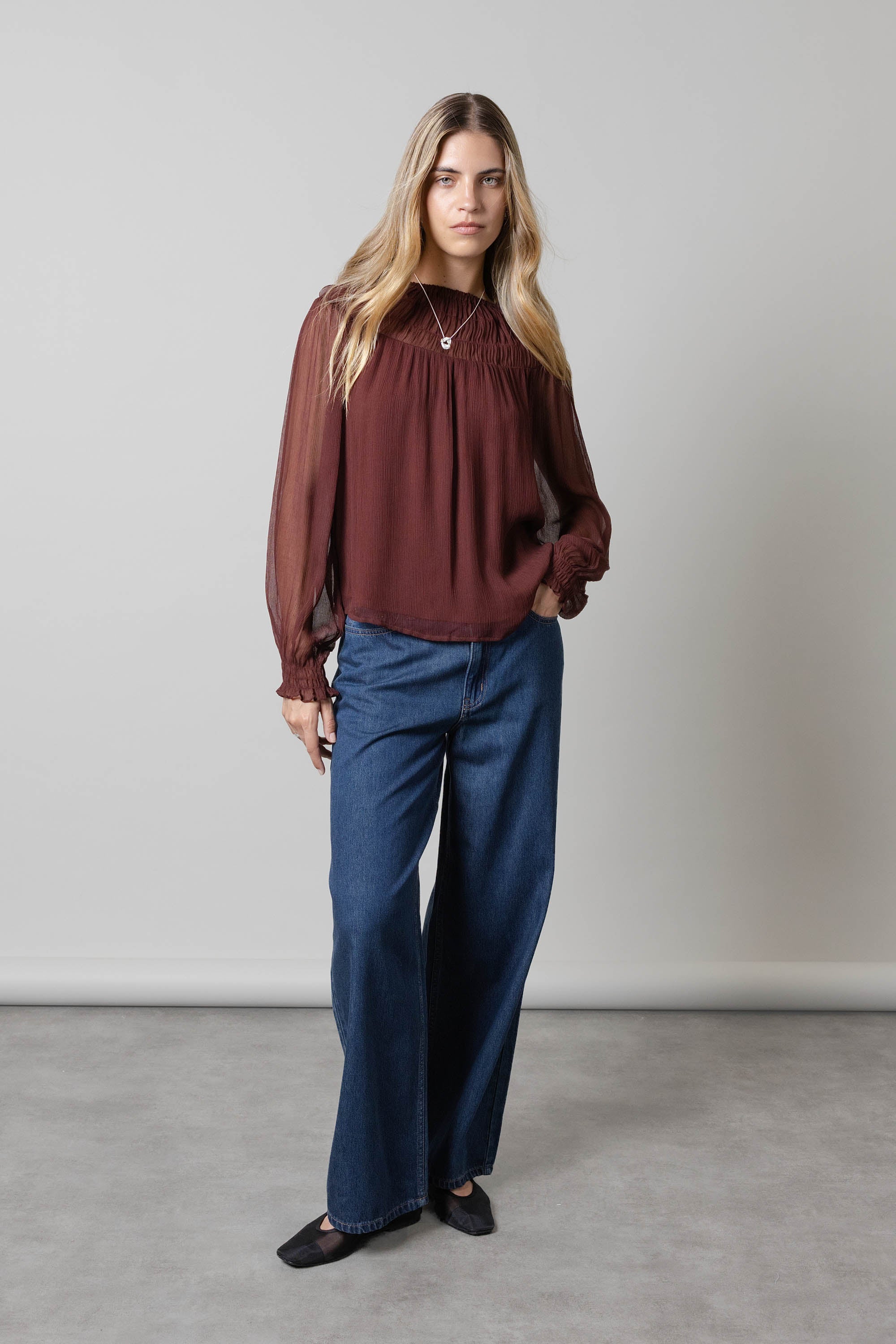 Woman in Max Aspen Wide Leg Jeans and maroon blouse against a plain background.