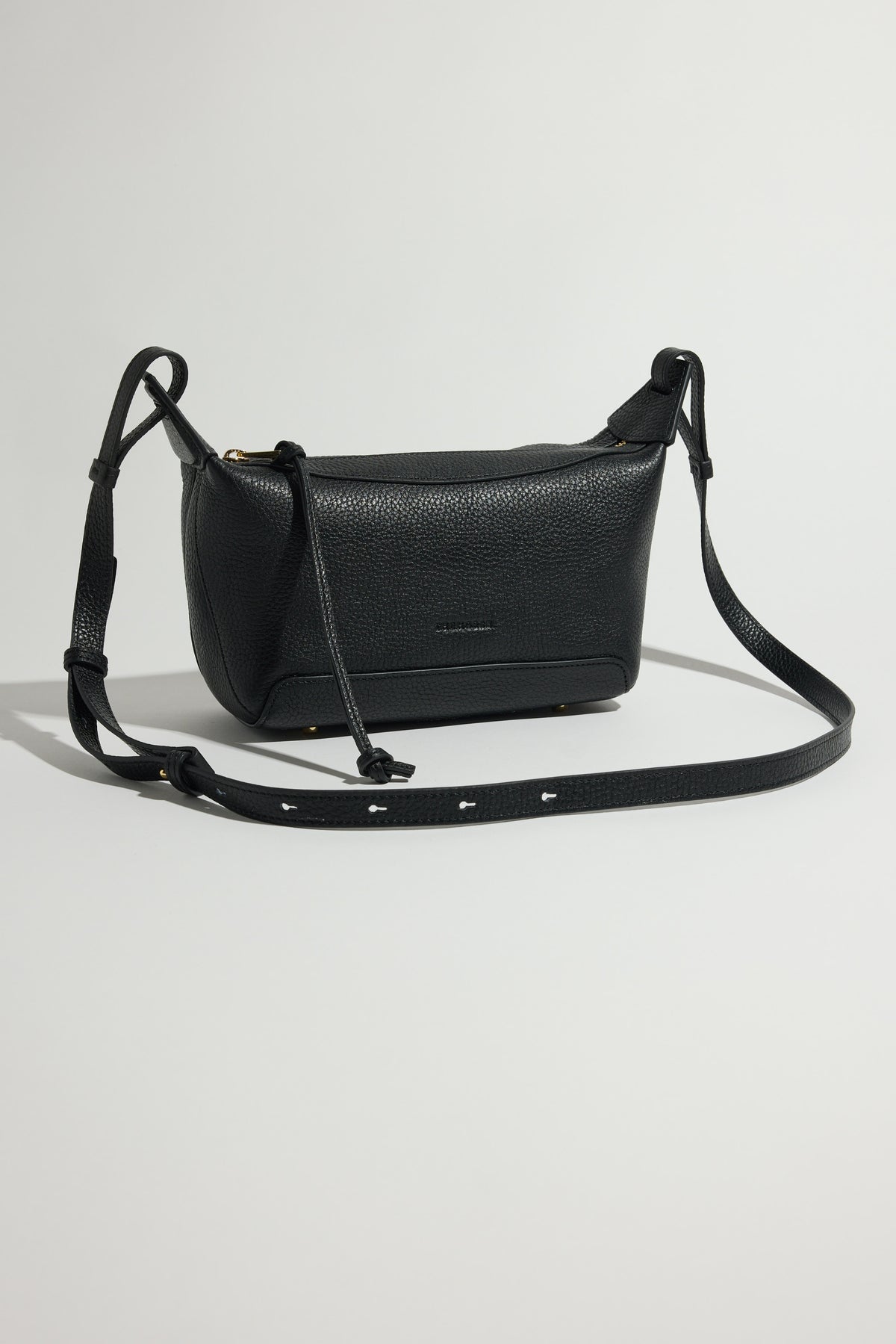 The Horse Mini Lou Bag in pebble leather with adjustable strap on a light gray background.