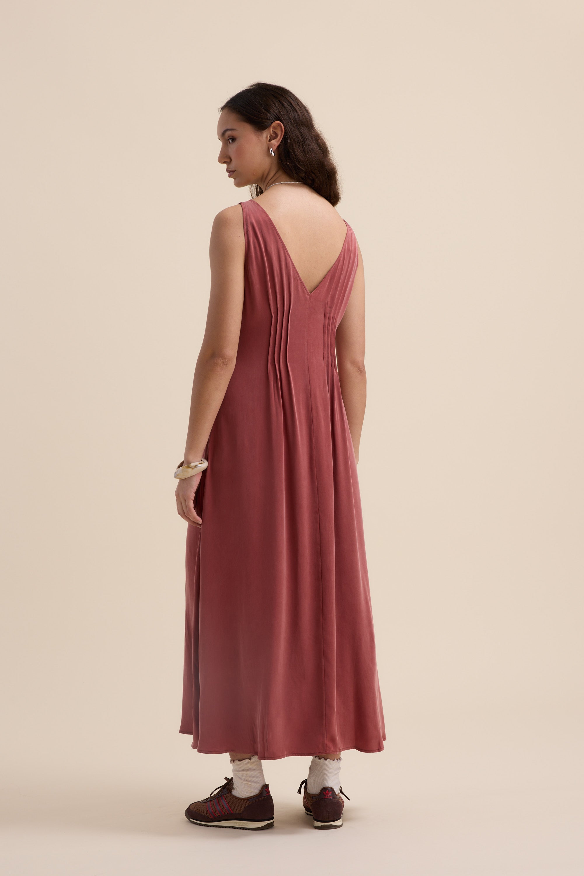 Woman in a sleeveless pink Cara Pleat Detail Dress by Max, back to the camera.