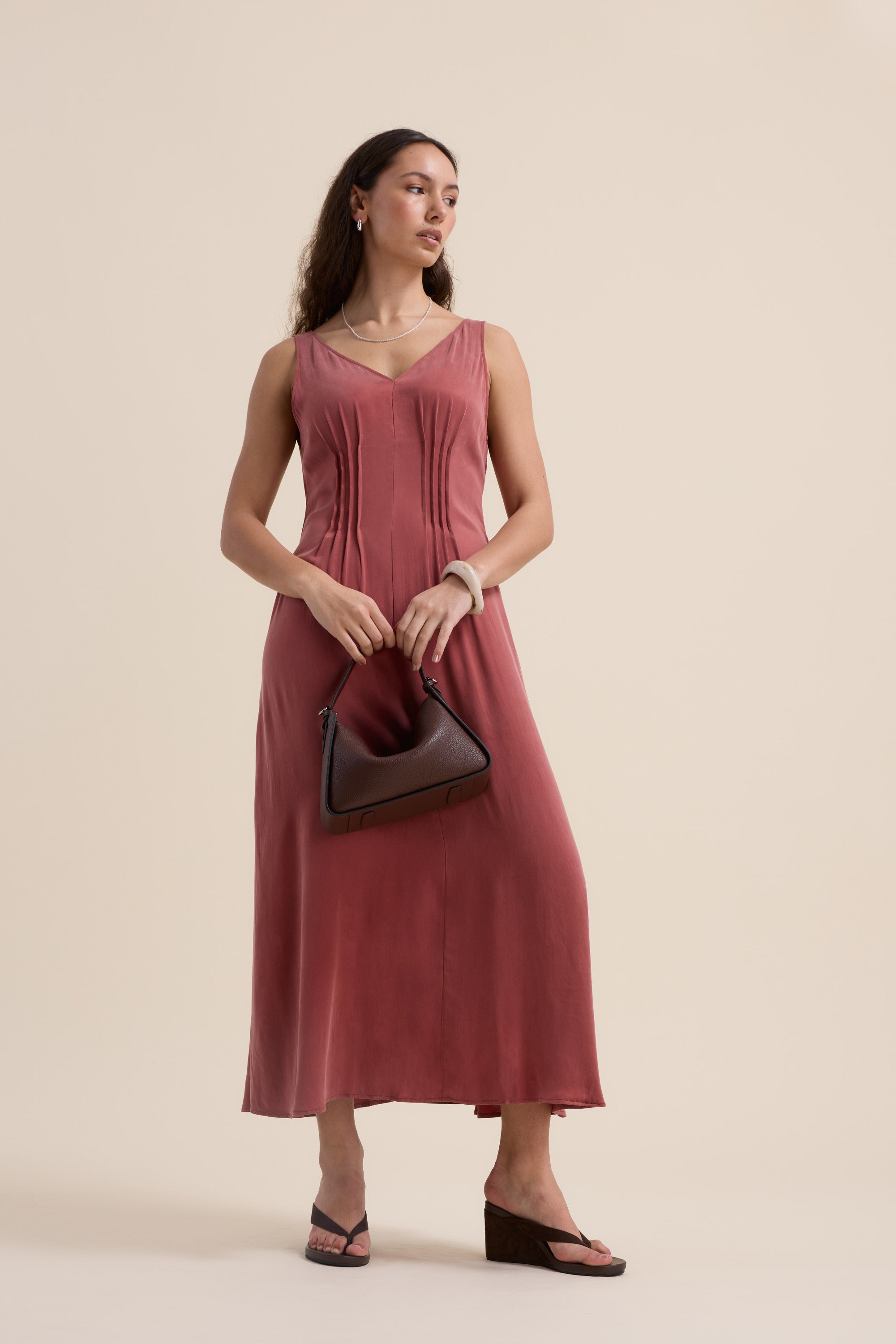 Woman in Max Cara Pleat Detail Dress holds a brown handbag, wearing wedge sandals.