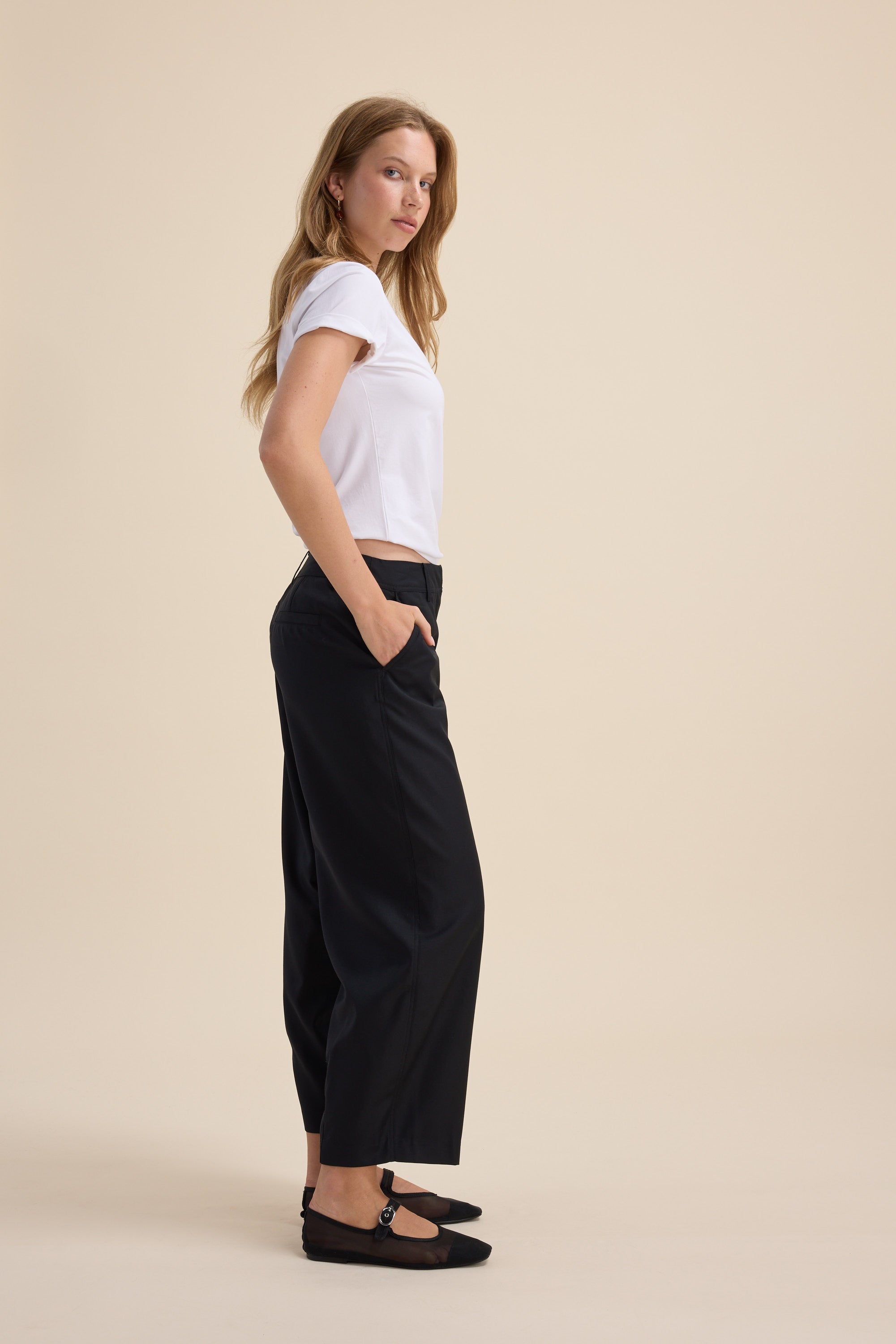 Woman in a white tee and Max The Wool Blend Barrel Leg Pants, hands in pockets.