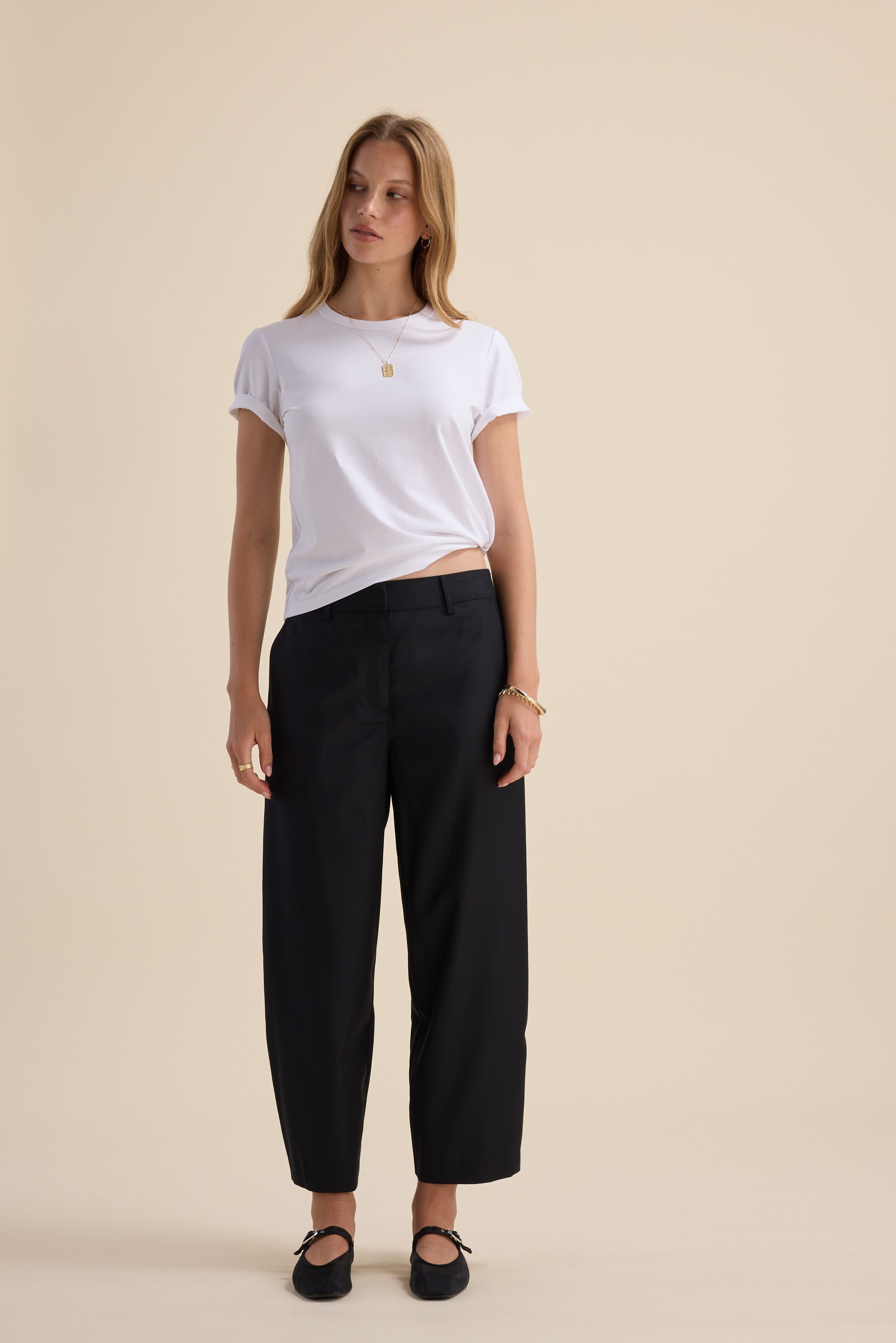 Woman in white tee and Max’s Wool Blend Barrel Leg Pants, paired with black flats.