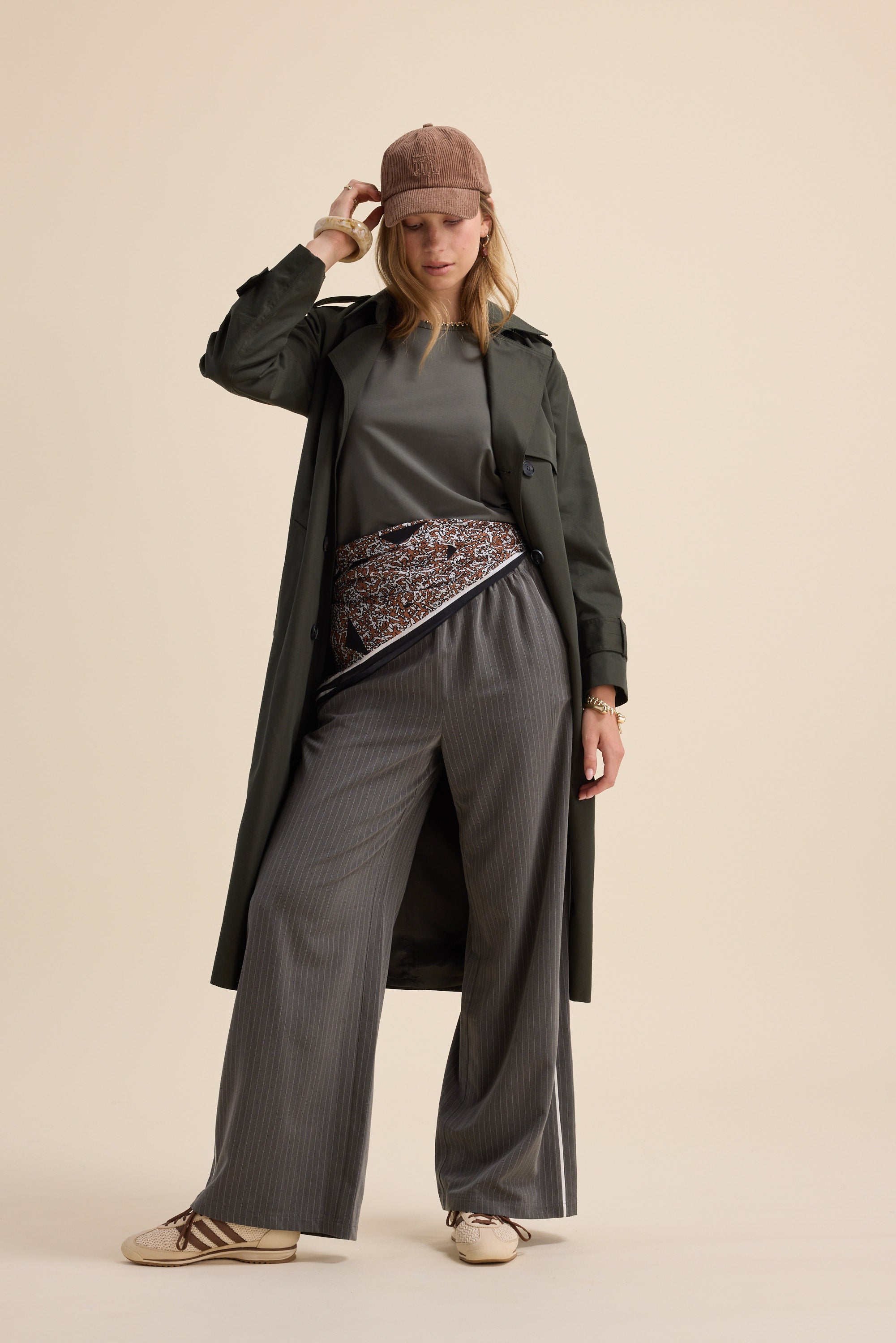 Woman in long coat, wide pants, cap, and Max's The Perfect Short Sleeve Crew Neck Tee poses with waist bag.