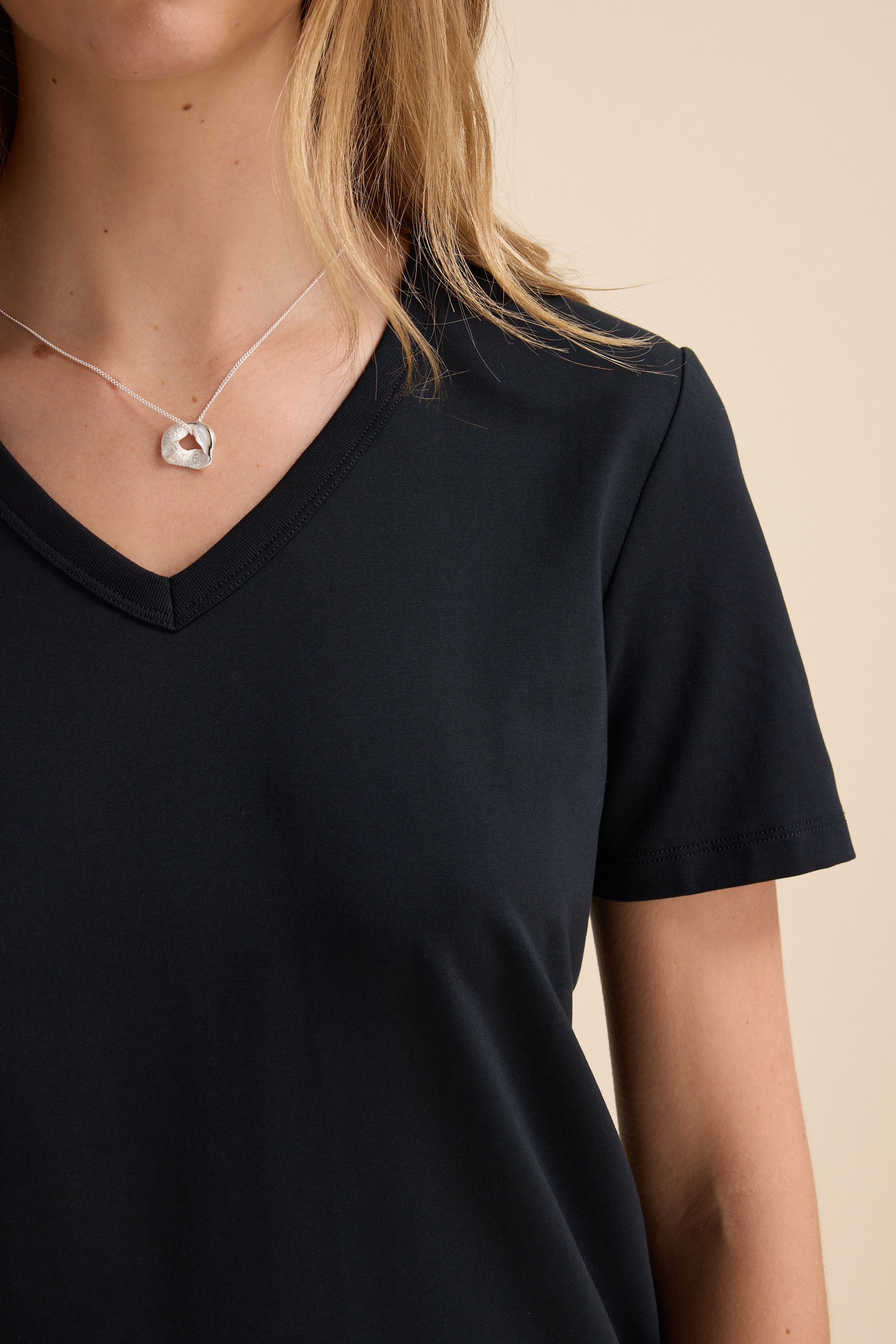 Woman in Max's Perfect Short Sleeve V Neck Tee and a silver pendant necklace.