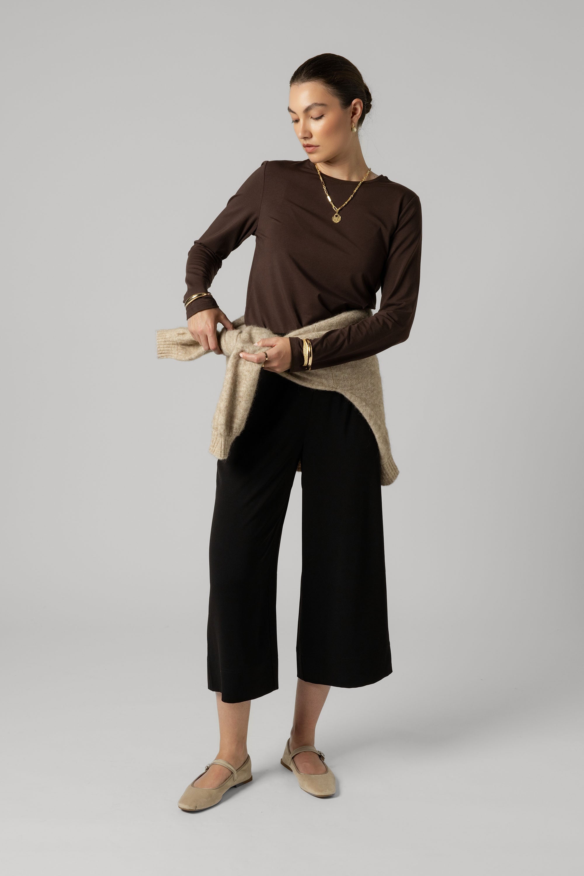 Woman in The Perfect Long Sleeve Crew Tee by Max, sweater tied around her waist.