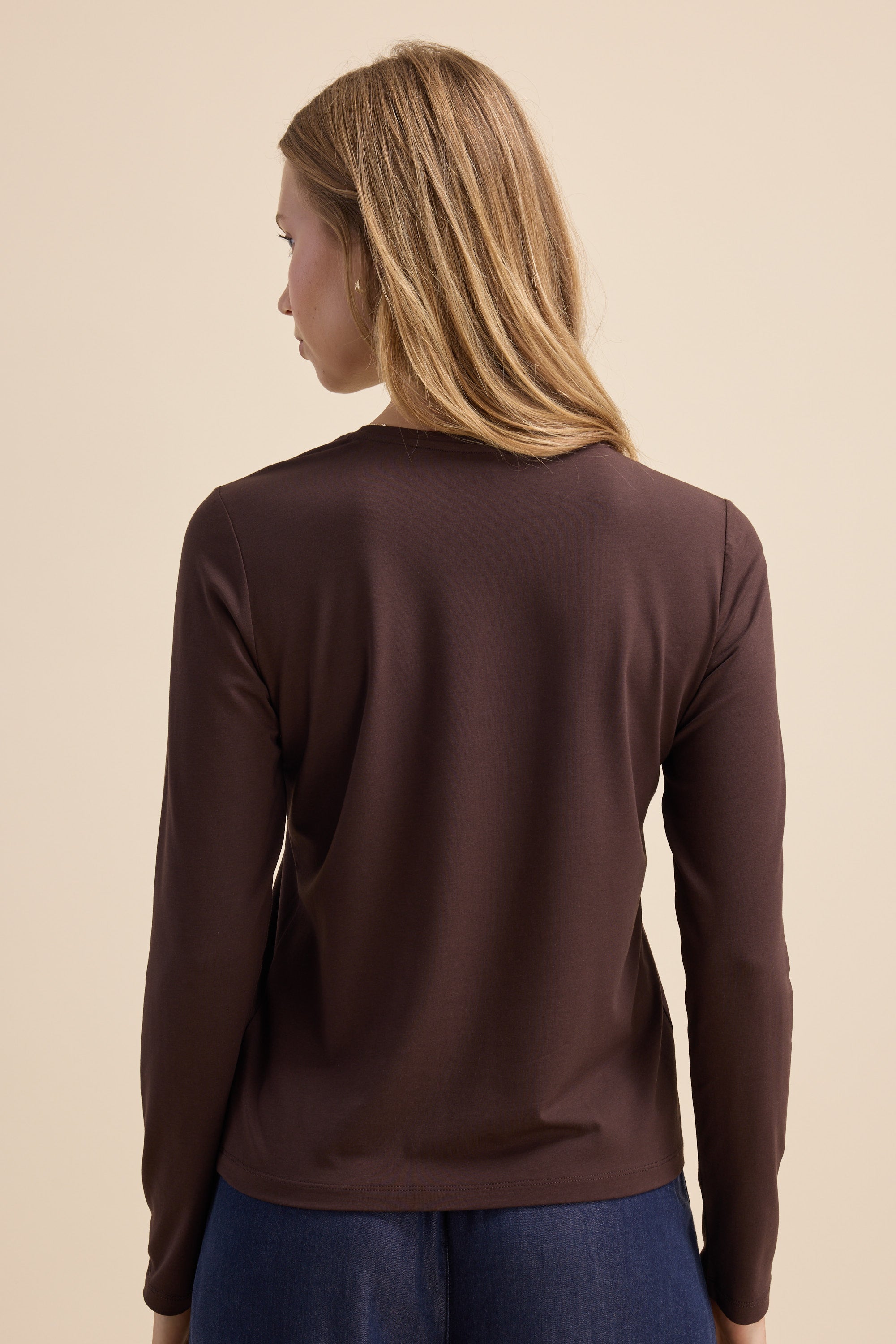A woman with long blonde hair wears the Max Perfect Long Sleeve Crew Tee, facing away.