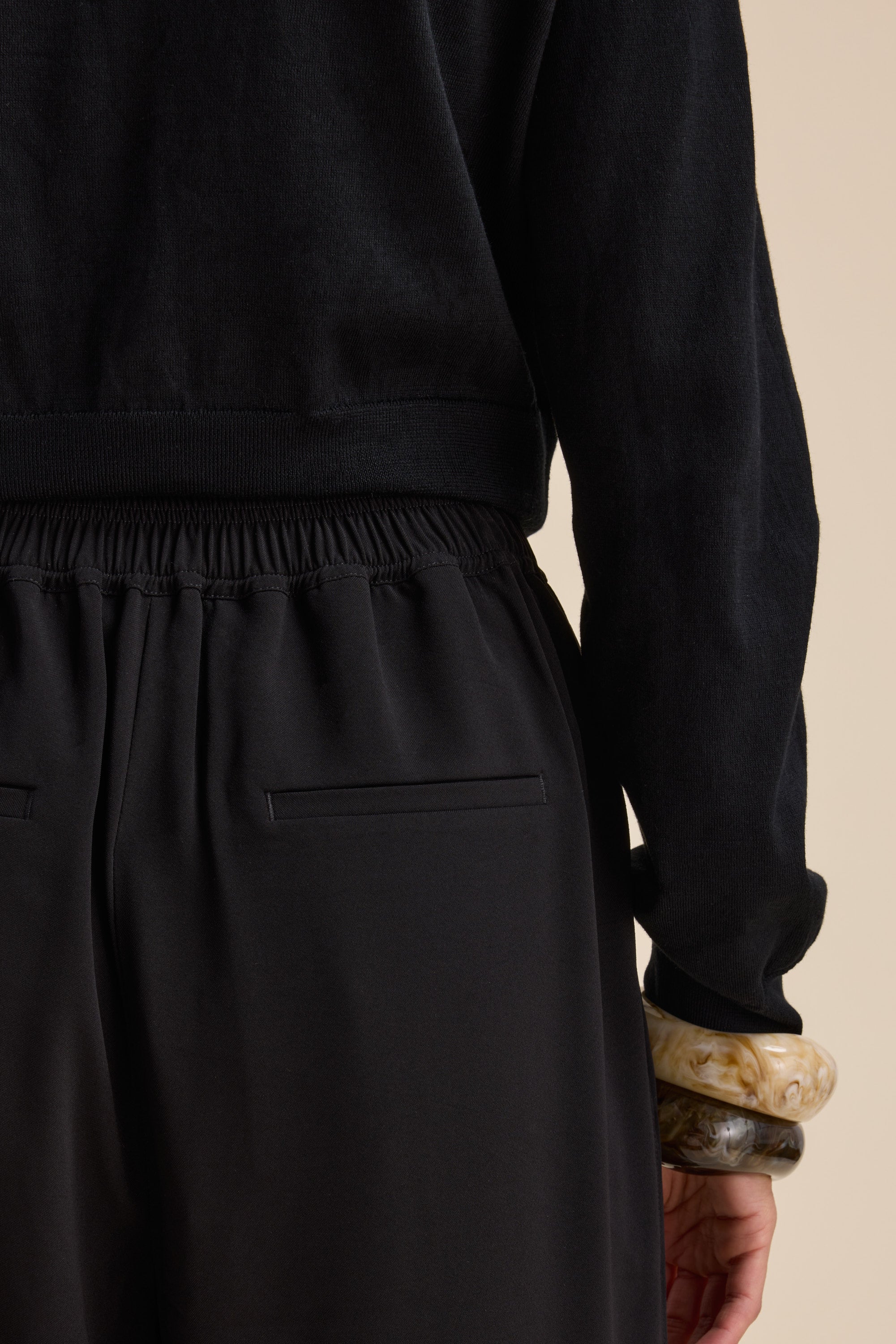Person wearing Max's The Easy Care Wide Leg Crop Pants in black, paired with a black top.