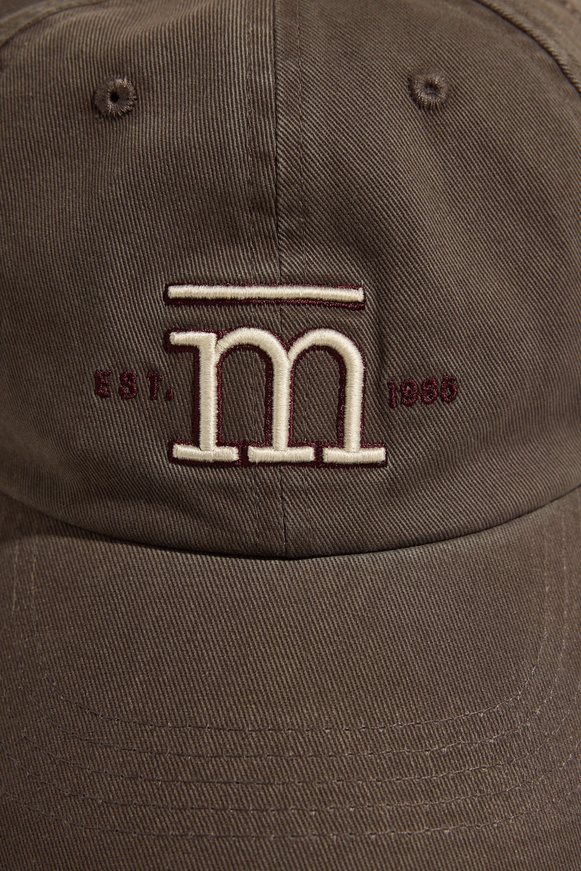 Max Elementary Washed Back Cap: brown, white M logo, maroon EST. 1986, adjustable strap.