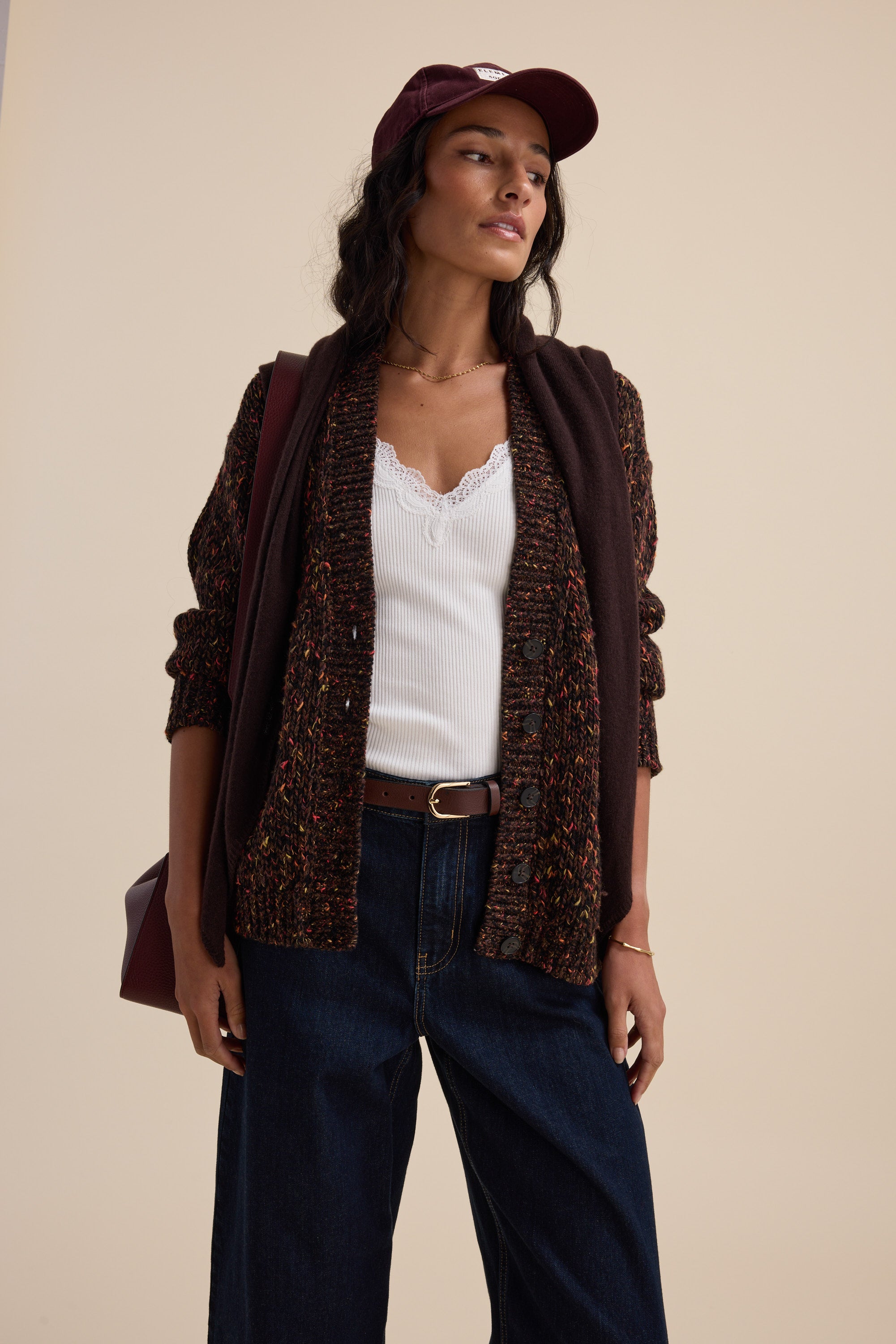 Woman in maroon cap and jeans wears Elementary Oversized Merino Blend Cardigan by Elementary.
