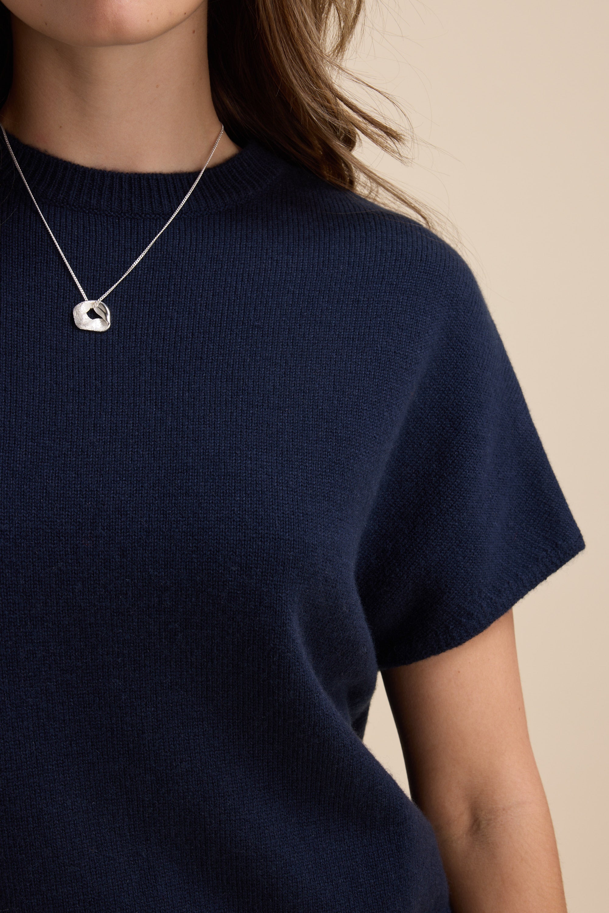 Woman in Elementary Cashmere Blend Drop Shoulder Top and a silver pendant necklace.