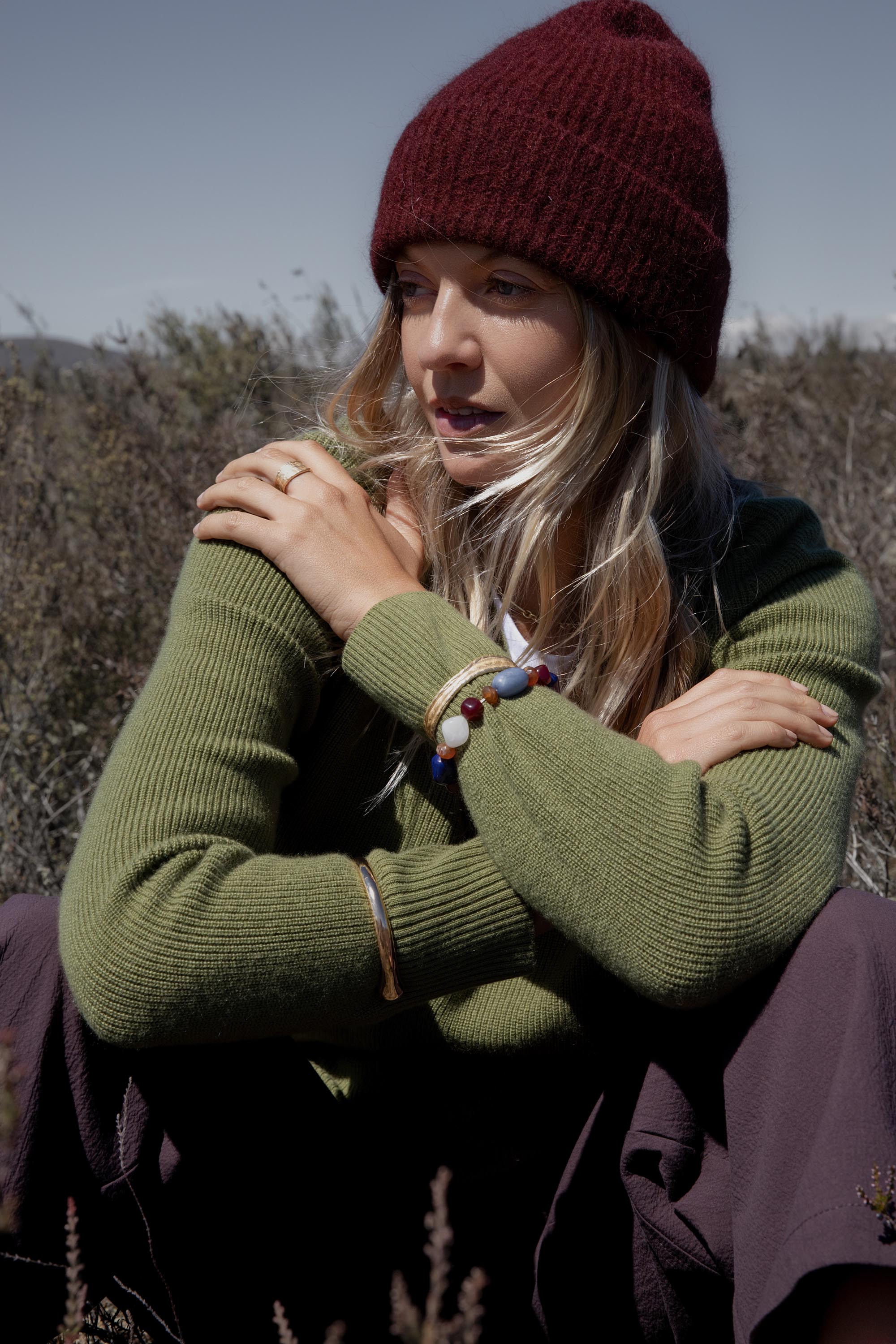 Woman in Elementary Cashmere Blend V Neck Sweater sits outdoors with arms crossed.