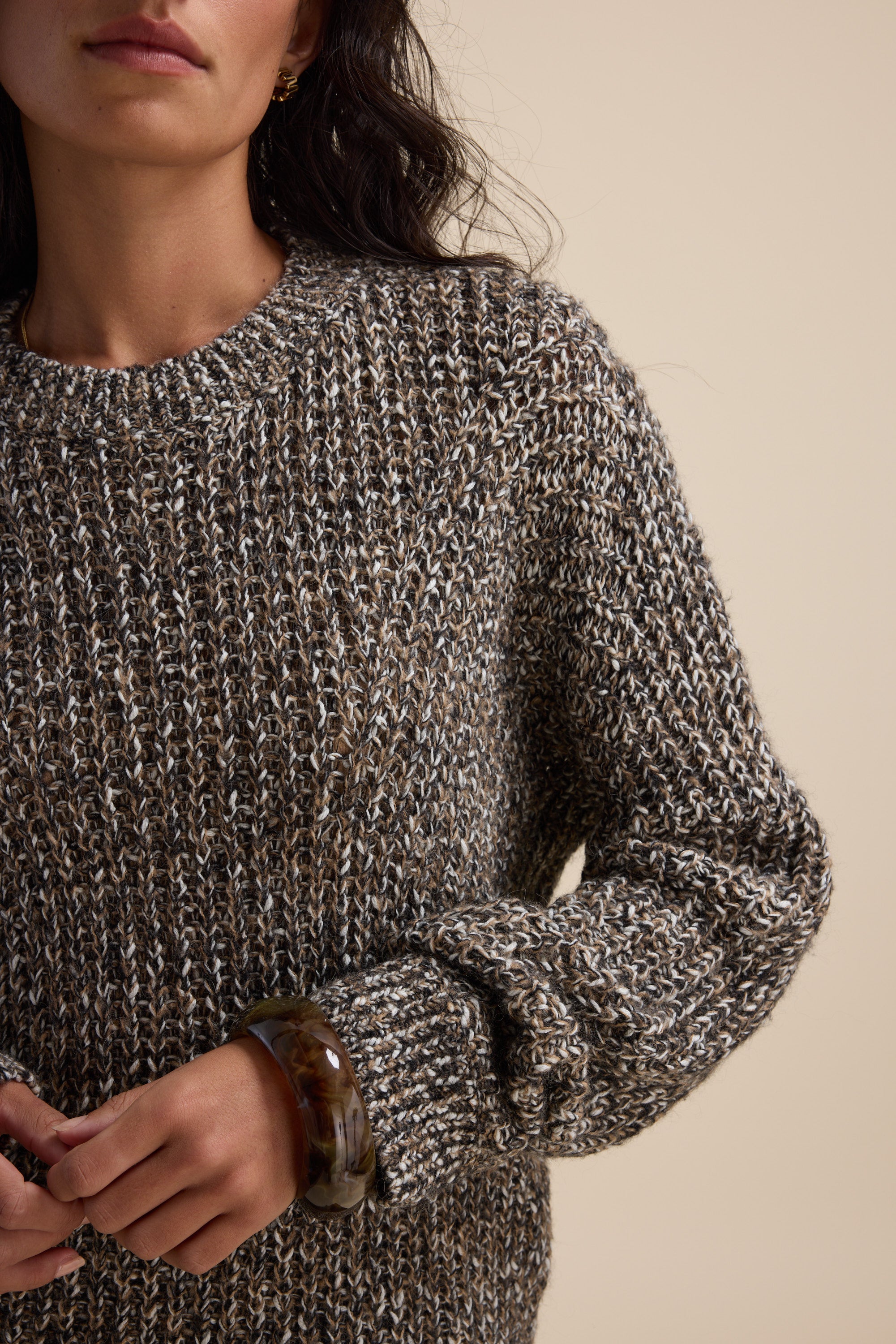 Woman wears the Elementary Chunky Knit Sweater, shown waist up with a large brown bangle.
