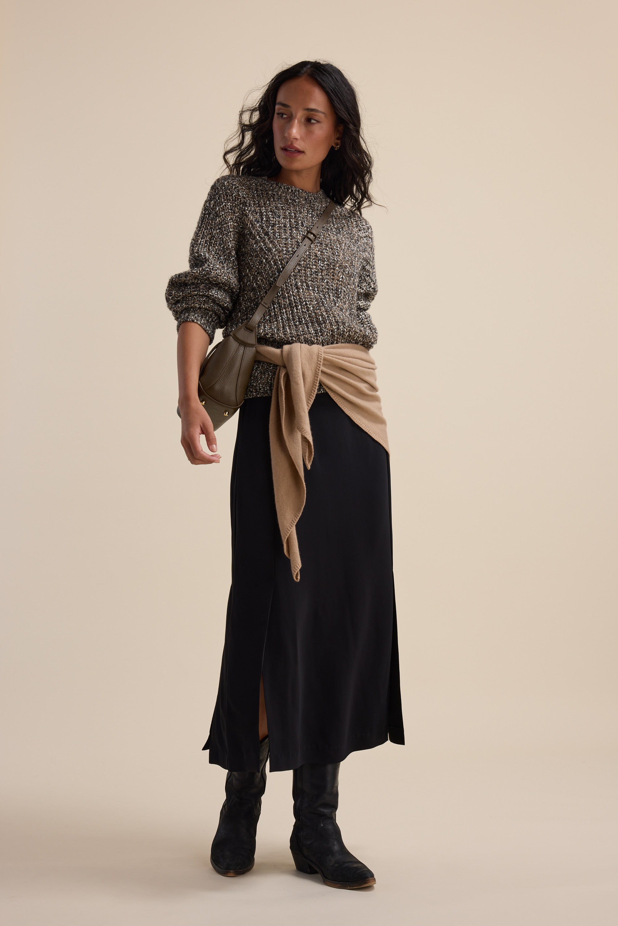 Woman in the Elementary Chunky Knit Sweater, long black skirt, boots, and crossbody bag.