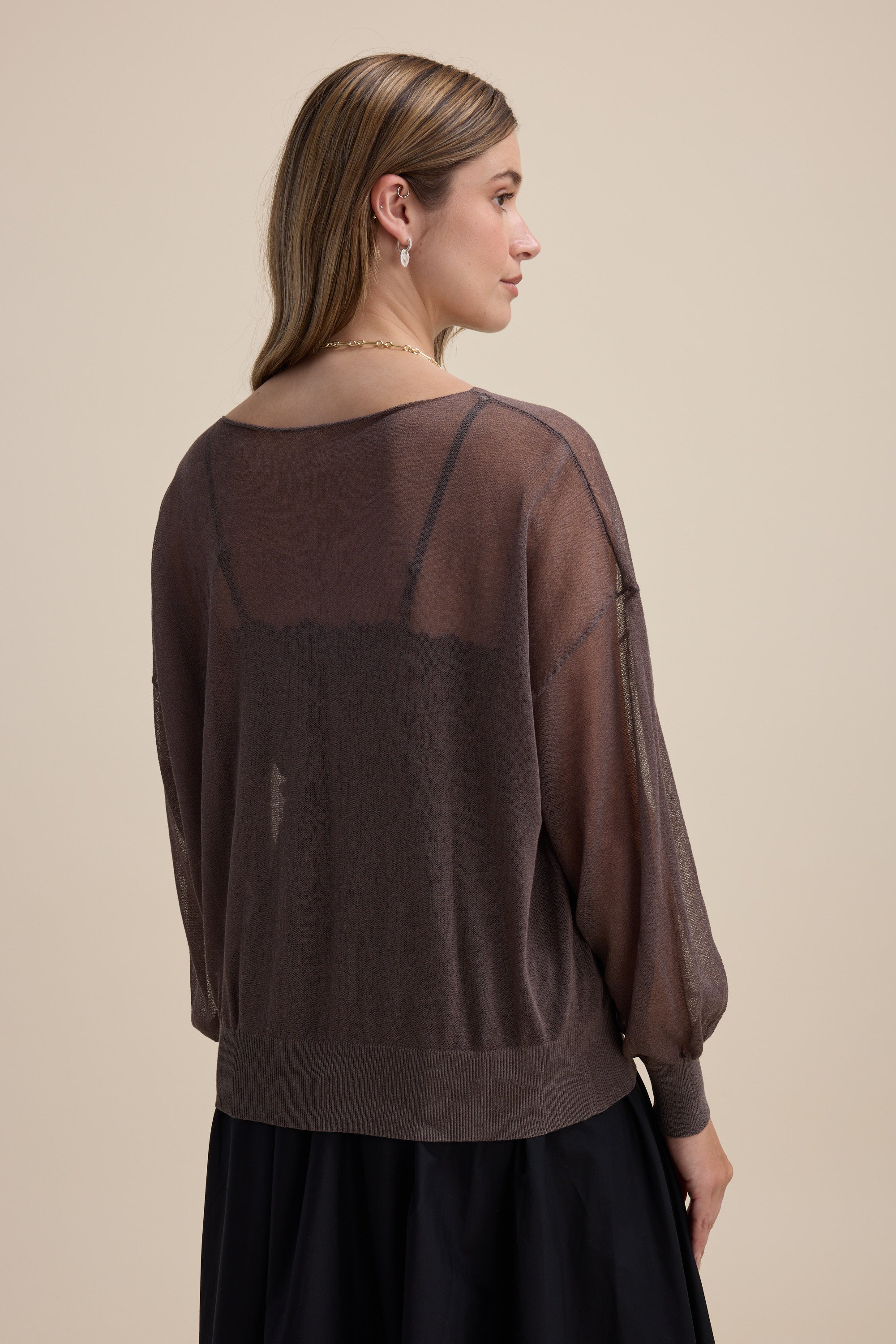 Woman in the Max Addie Sheer Knitted Top and black skirt, facing away with light brown hair.