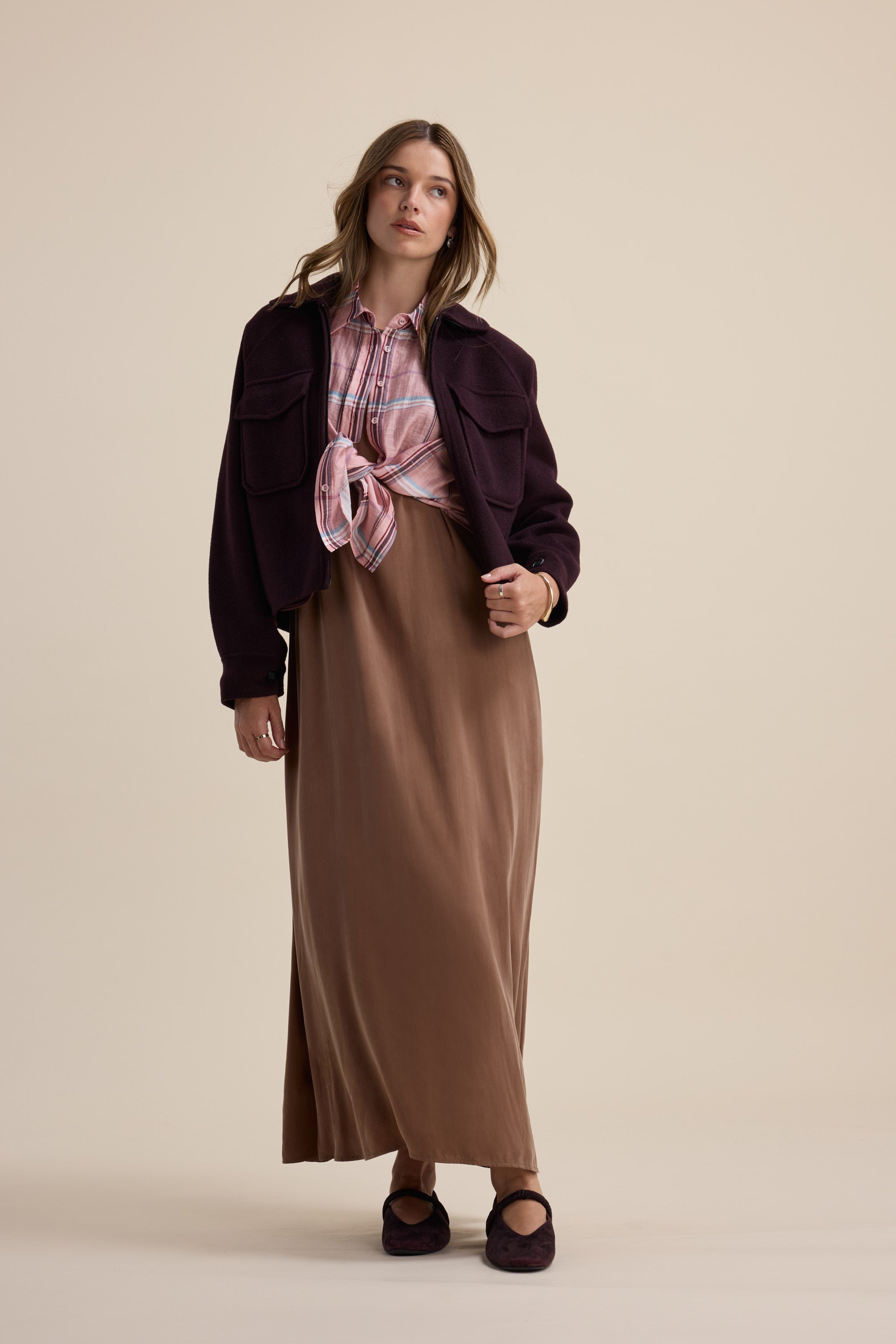 Woman in a Max Kaitlyn Flared Midi Dress, plaid shirt, dark jacket, and matching shoes indoors.