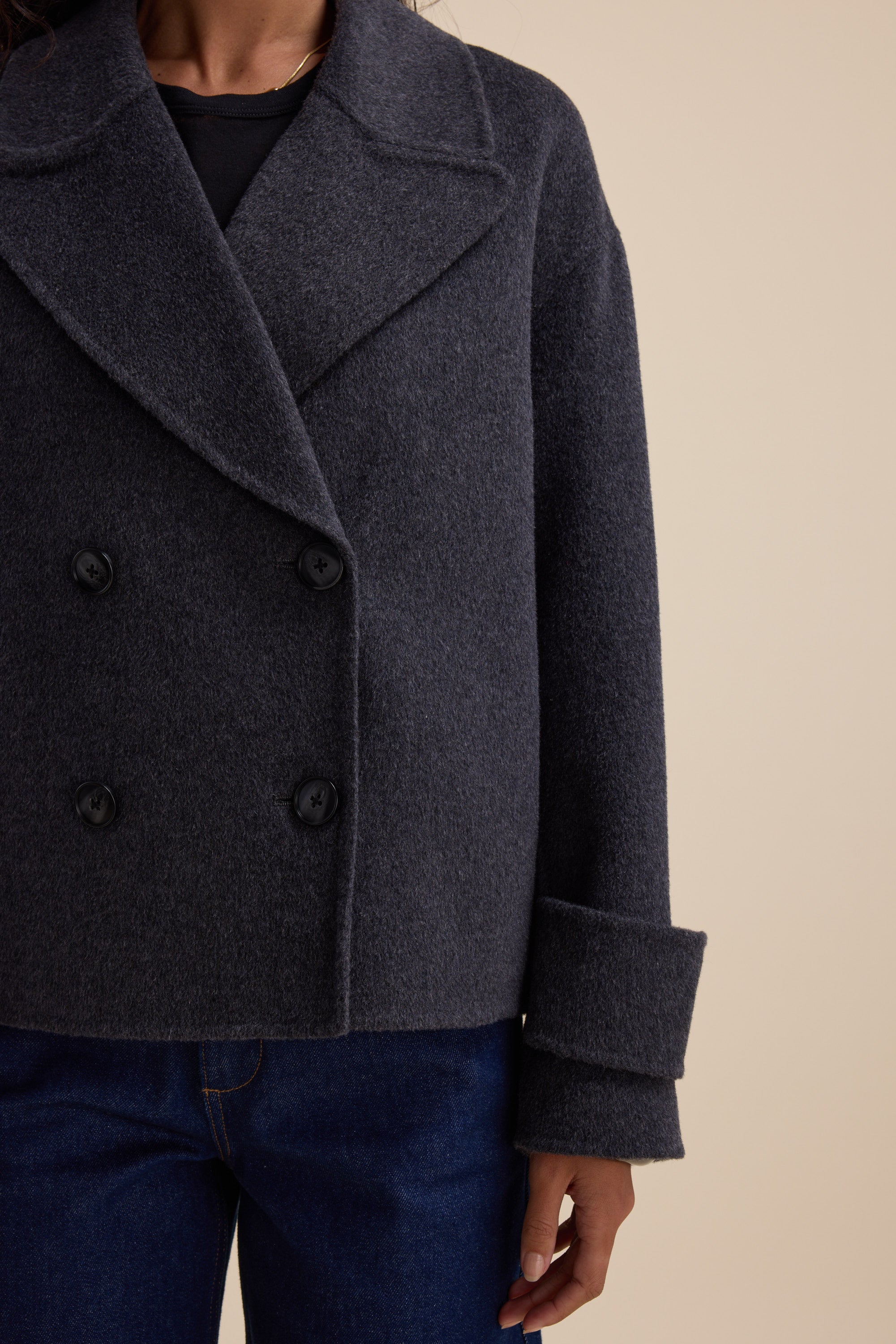 Person wearing Max's Double Breasted Wool Blend Coat with rolled sleeves and blue jeans.