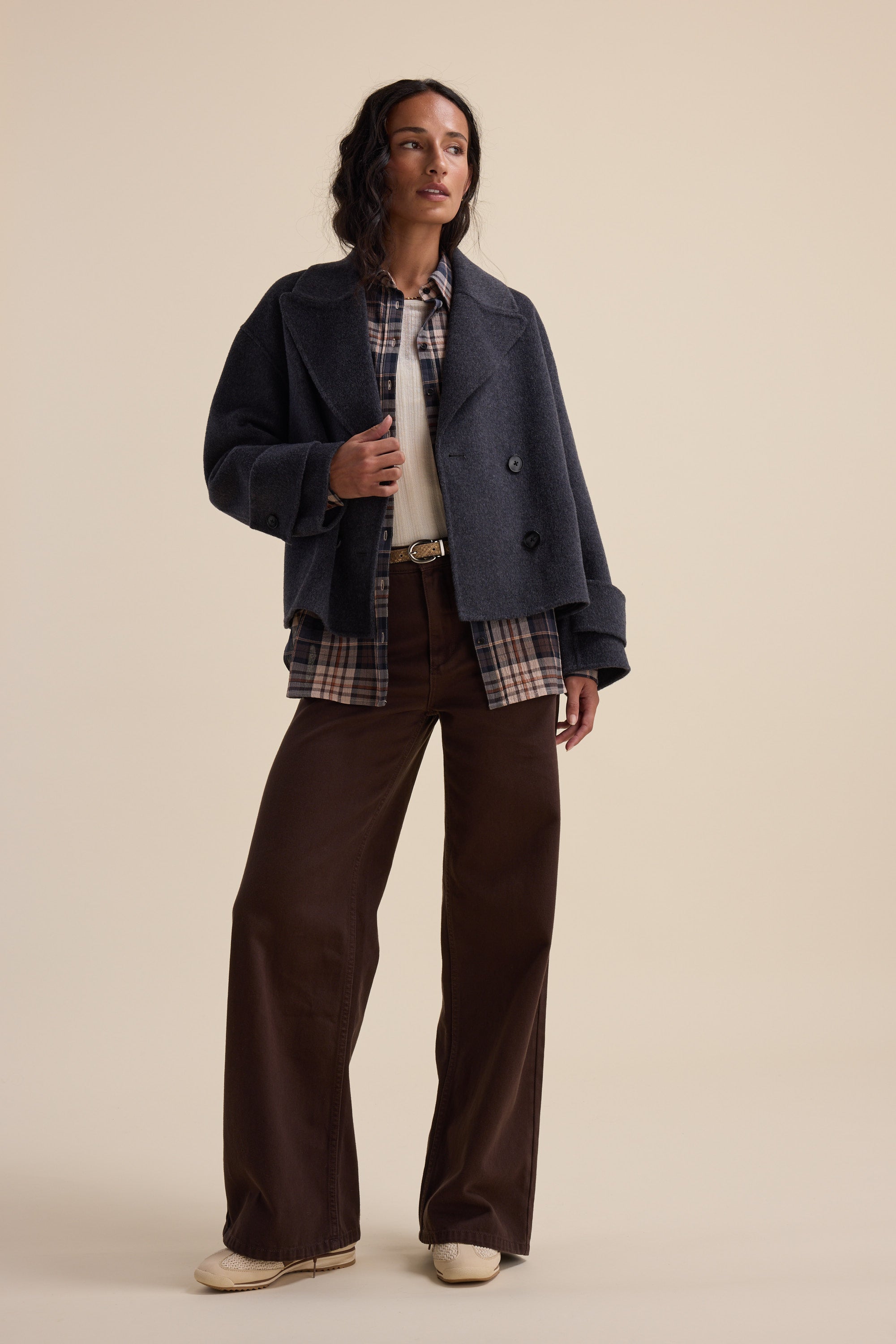 Woman wearing Max Alaska Wide Leg Jeans, gray coat, plaid shirt, and cream shoes.