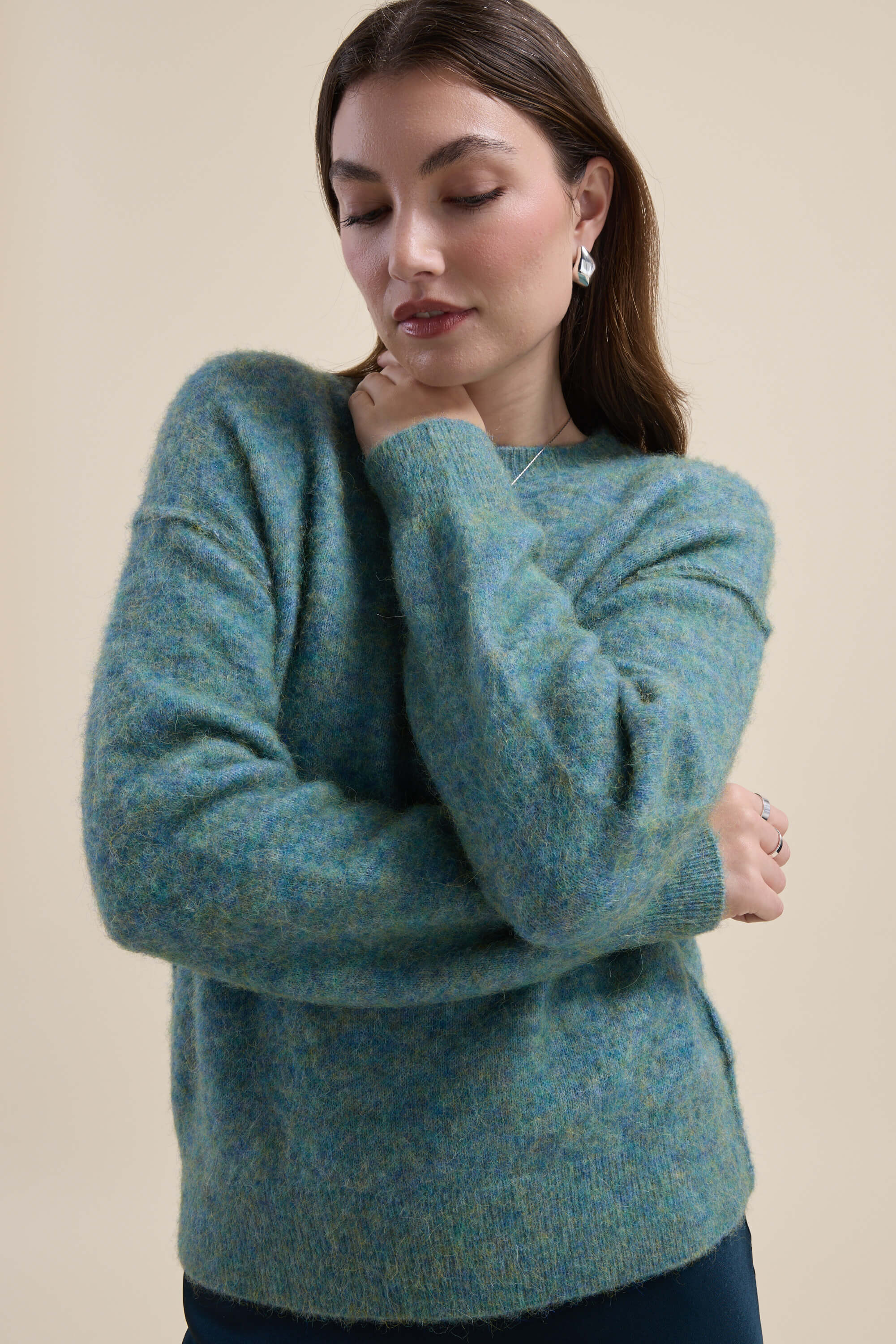 Woman wearing Max Devon Luxe Whisper Crew Neck Sweater crosses her arms against a beige background.