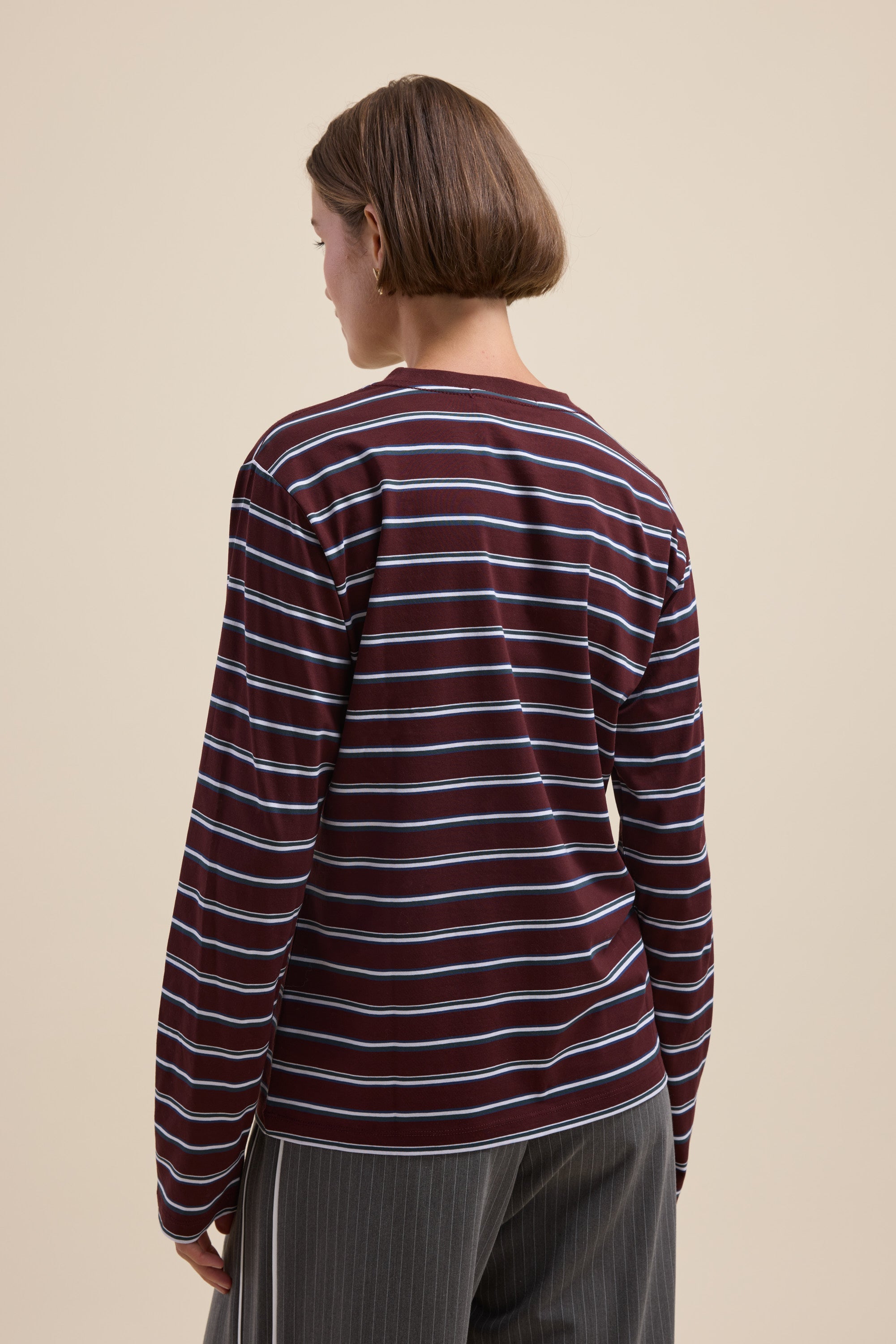 Person with short brown hair in a Max Carmen Long Sleeve Stripe Tee with a relaxed crew neckline.
