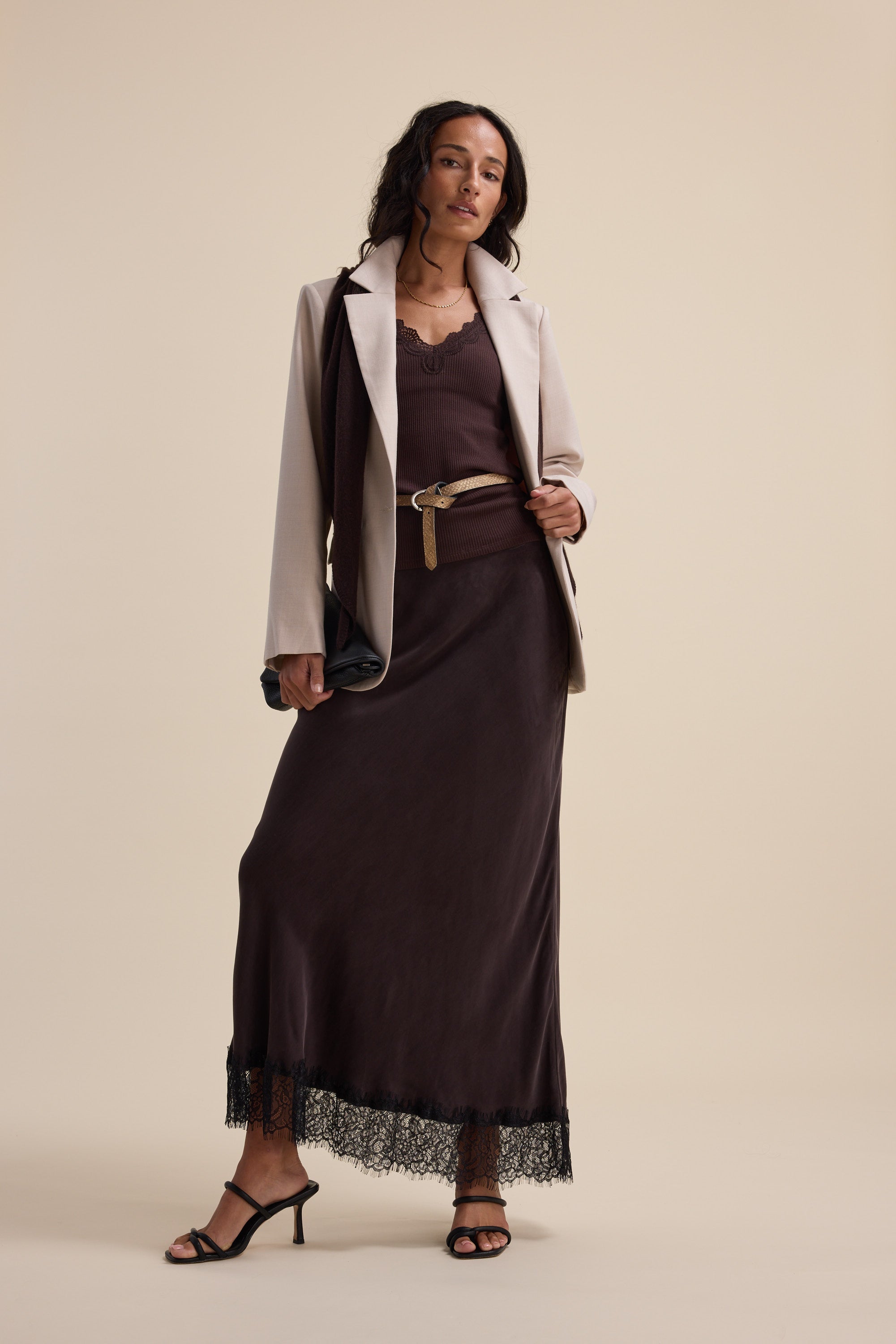 Woman in Max Aubree Lace Trim Tank, brown dress, beige blazer, heels, and black bag.