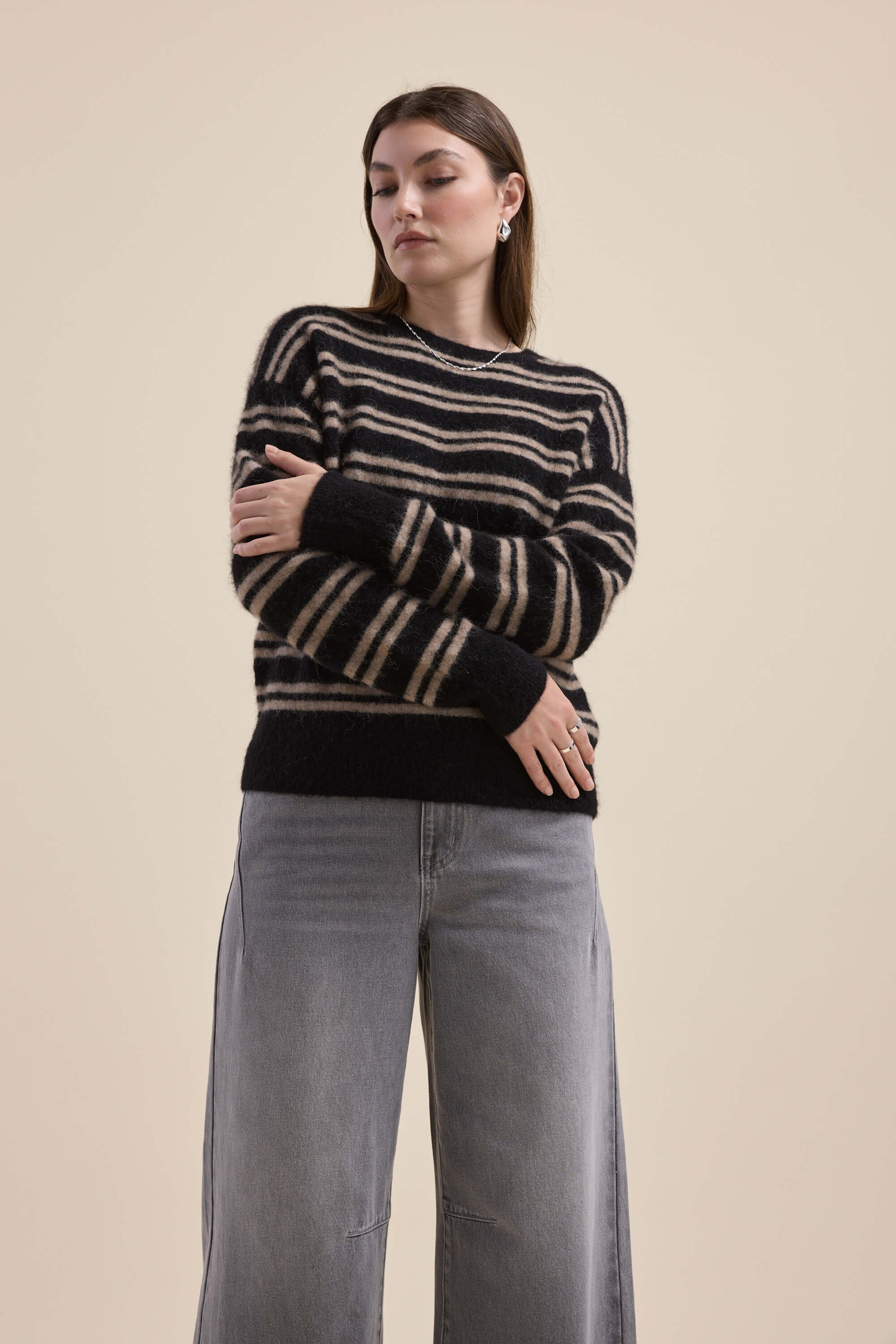 Model in Max's Juno Luxe Whisper Sweater and light gray jeans against a plain background.