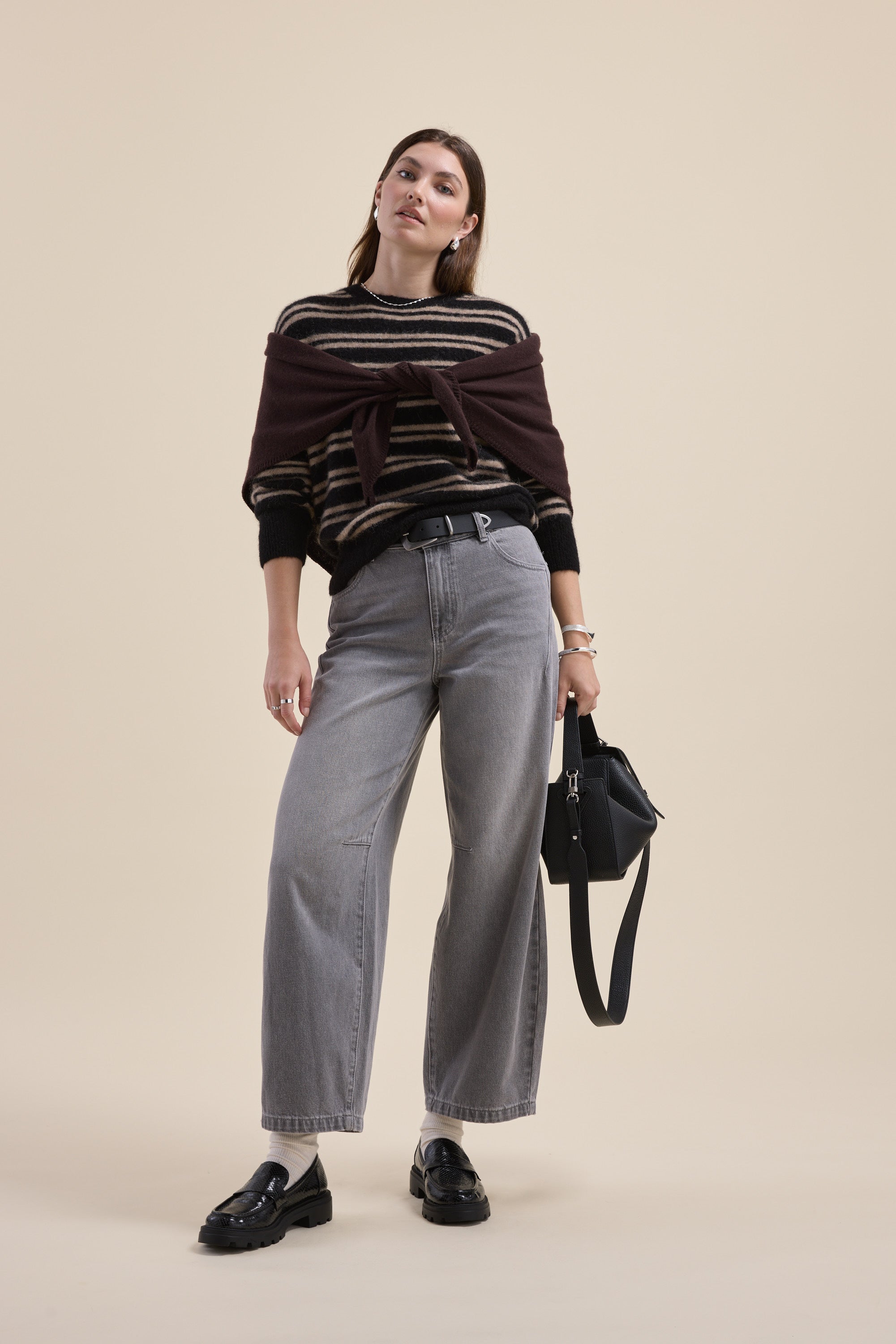 Woman in Juno Luxe Whisper Sweater by Max, gray wide-leg jeans, black shoes, black handbag.