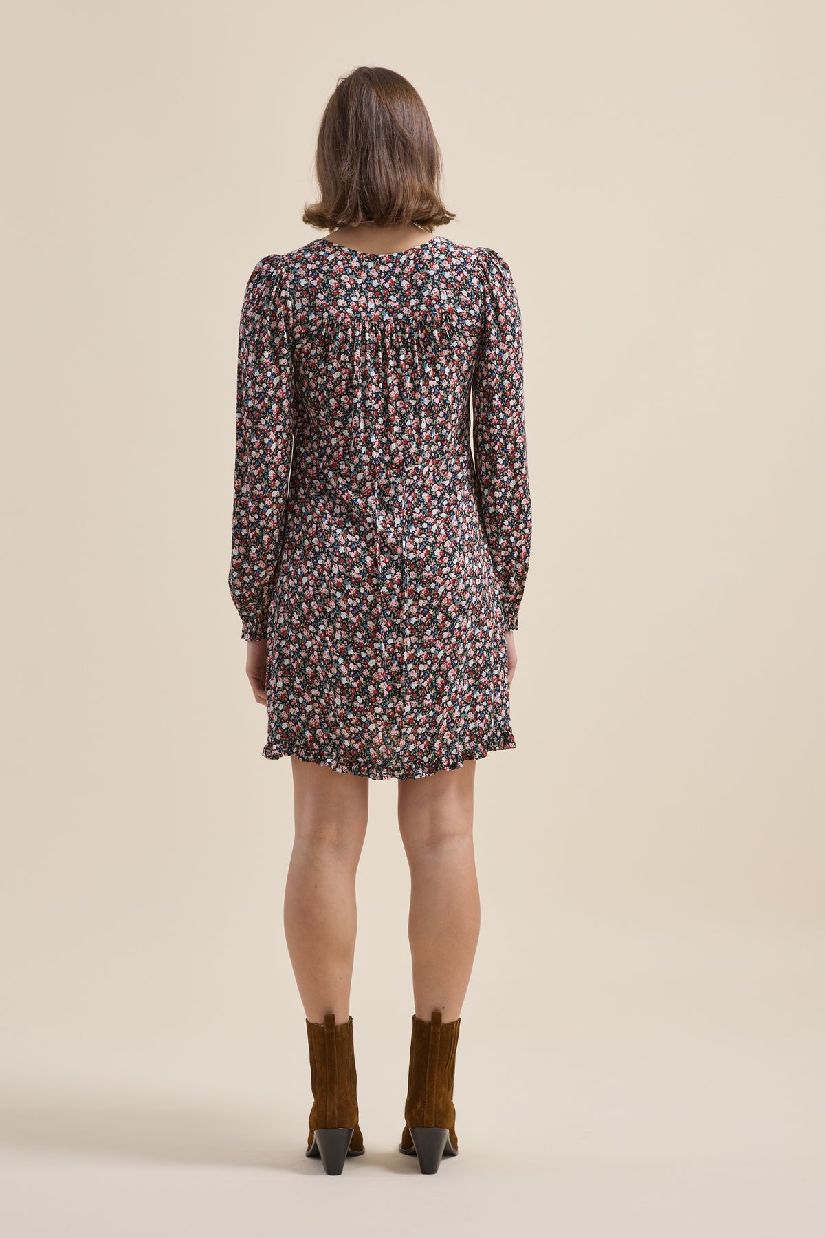 Woman in an Elementary Button Front Dress stands with her back to the camera.