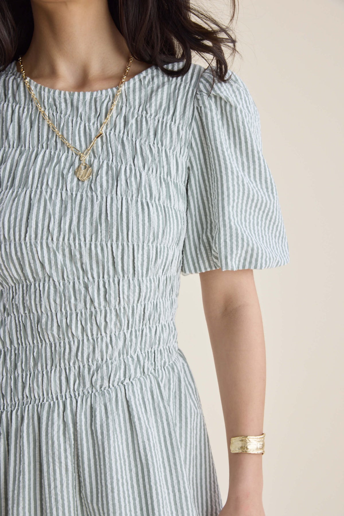 Woman in a Max Talia Shirred Detail Midi Dress with puff sleeves, made from organic cotton.
