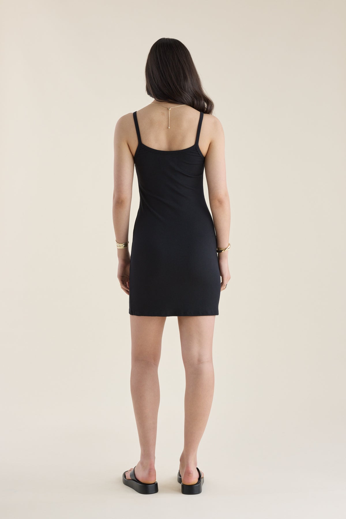 Woman in an Elementary Basics Rib Slip Dress by Elementary, back to camera, wearing sandals.