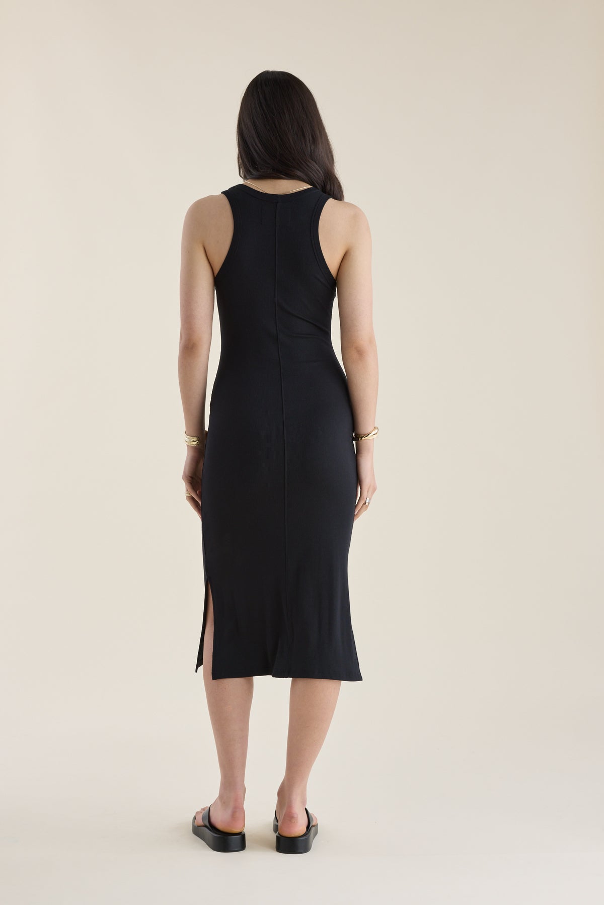 Woman in an Elementary Basics Tank Slip Dress by Elementary, back to camera, wearing sandals.