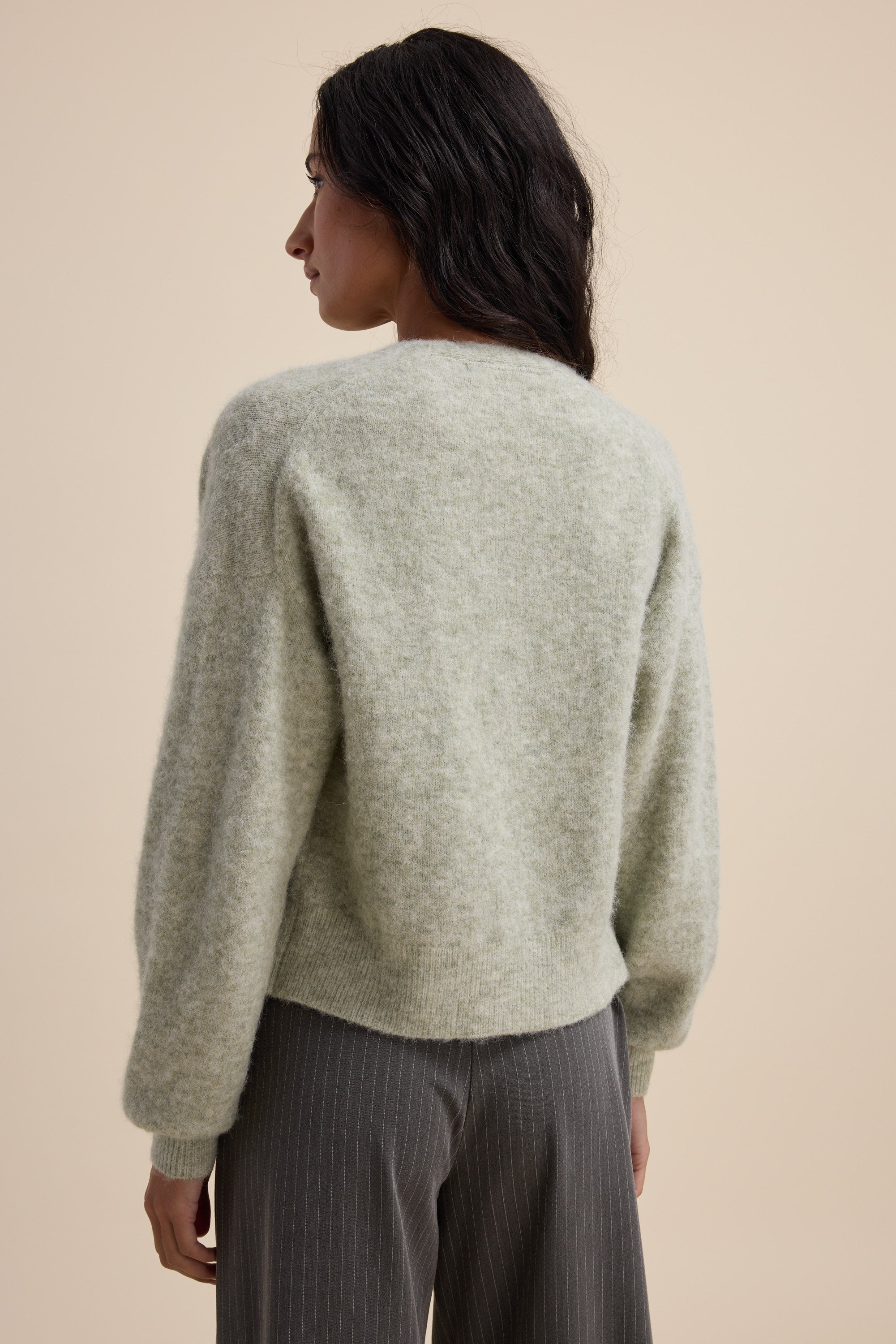 Woman in Max's The Ultimate Luxe Cardigan, seen from behind, with long dark hair.