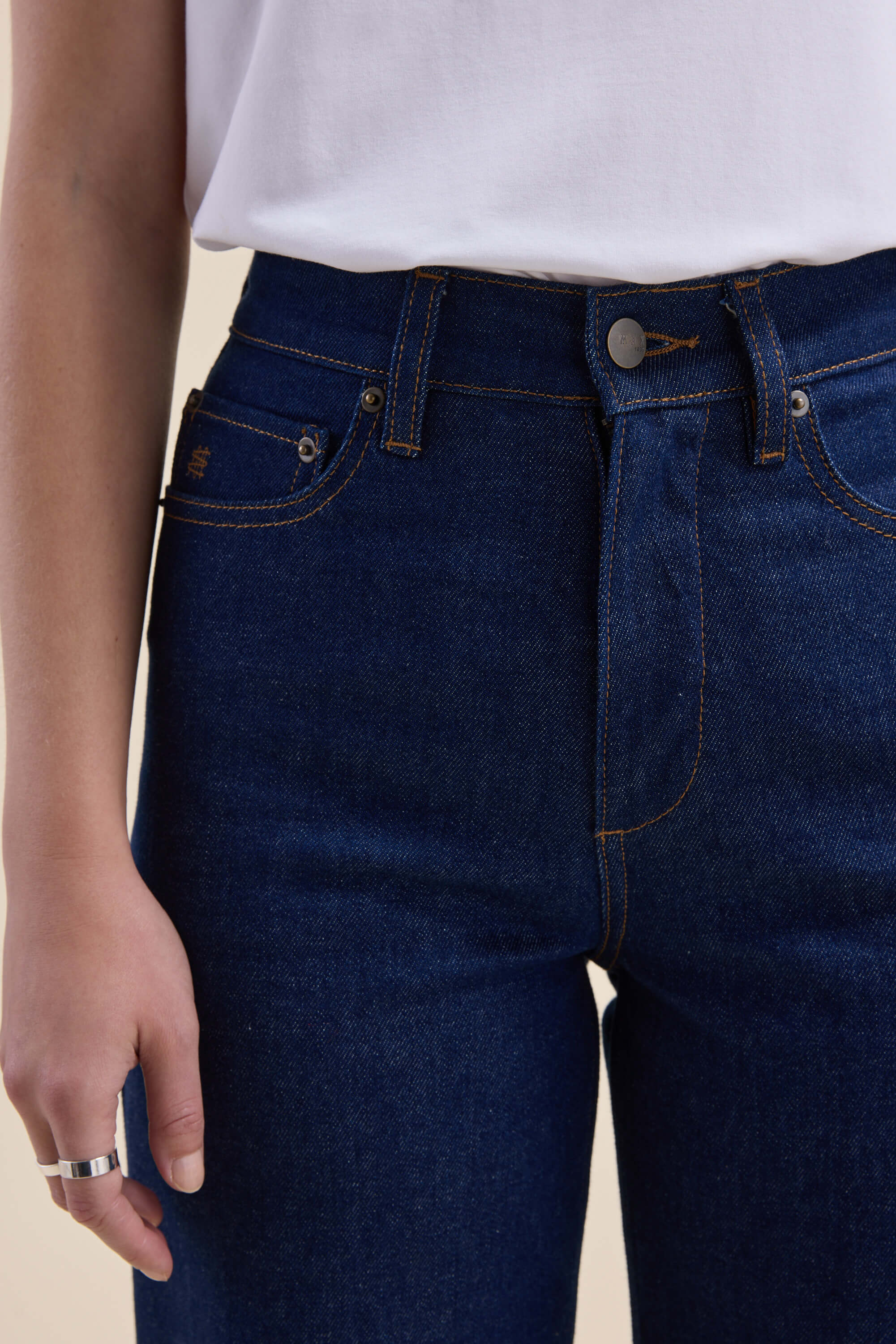 Person wearing Max's Nevada Wide Jeans and a white shirt, showing a silver ring on one hand.