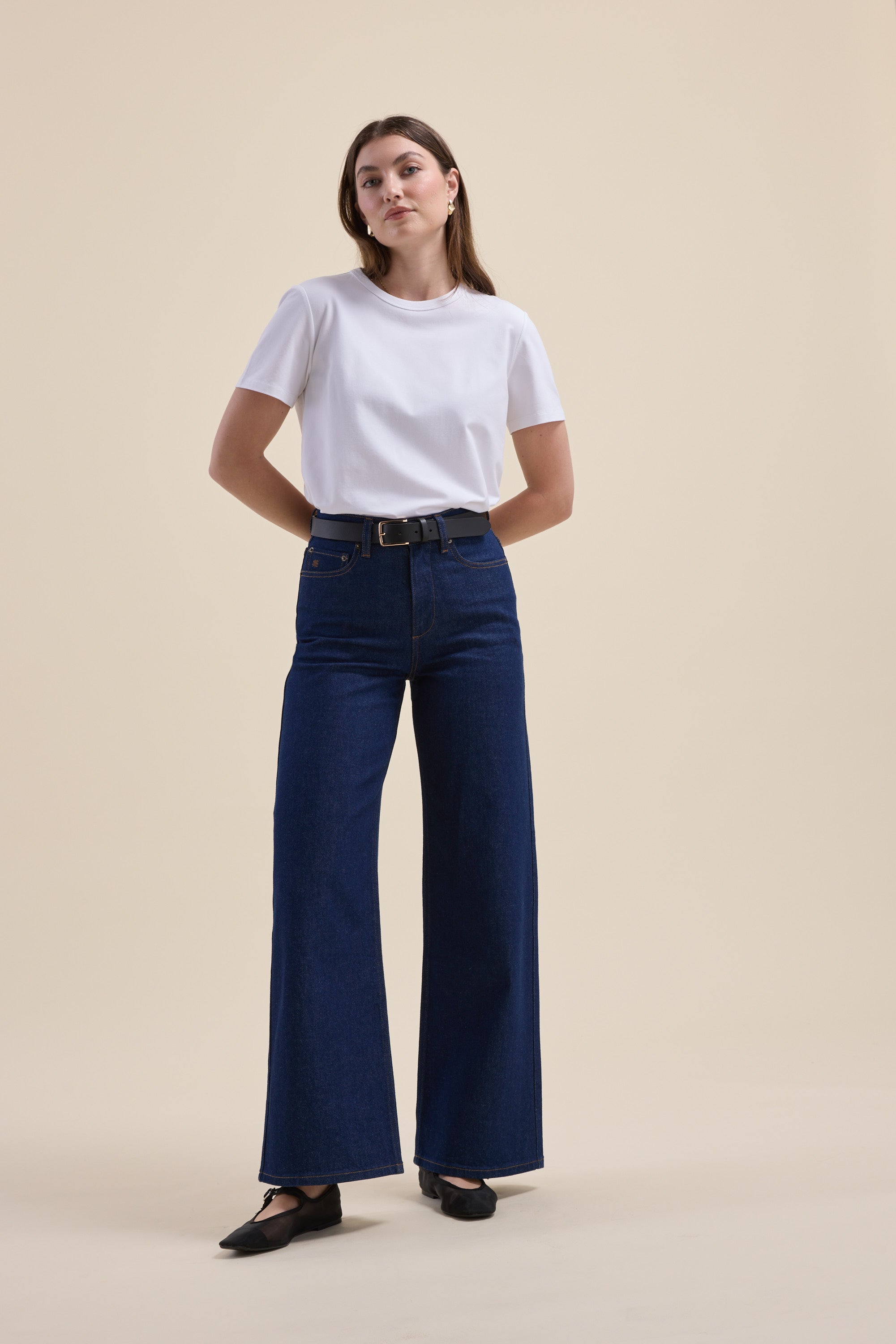 Woman in a white tee and Max Nevada Wide Jeans against a beige background.