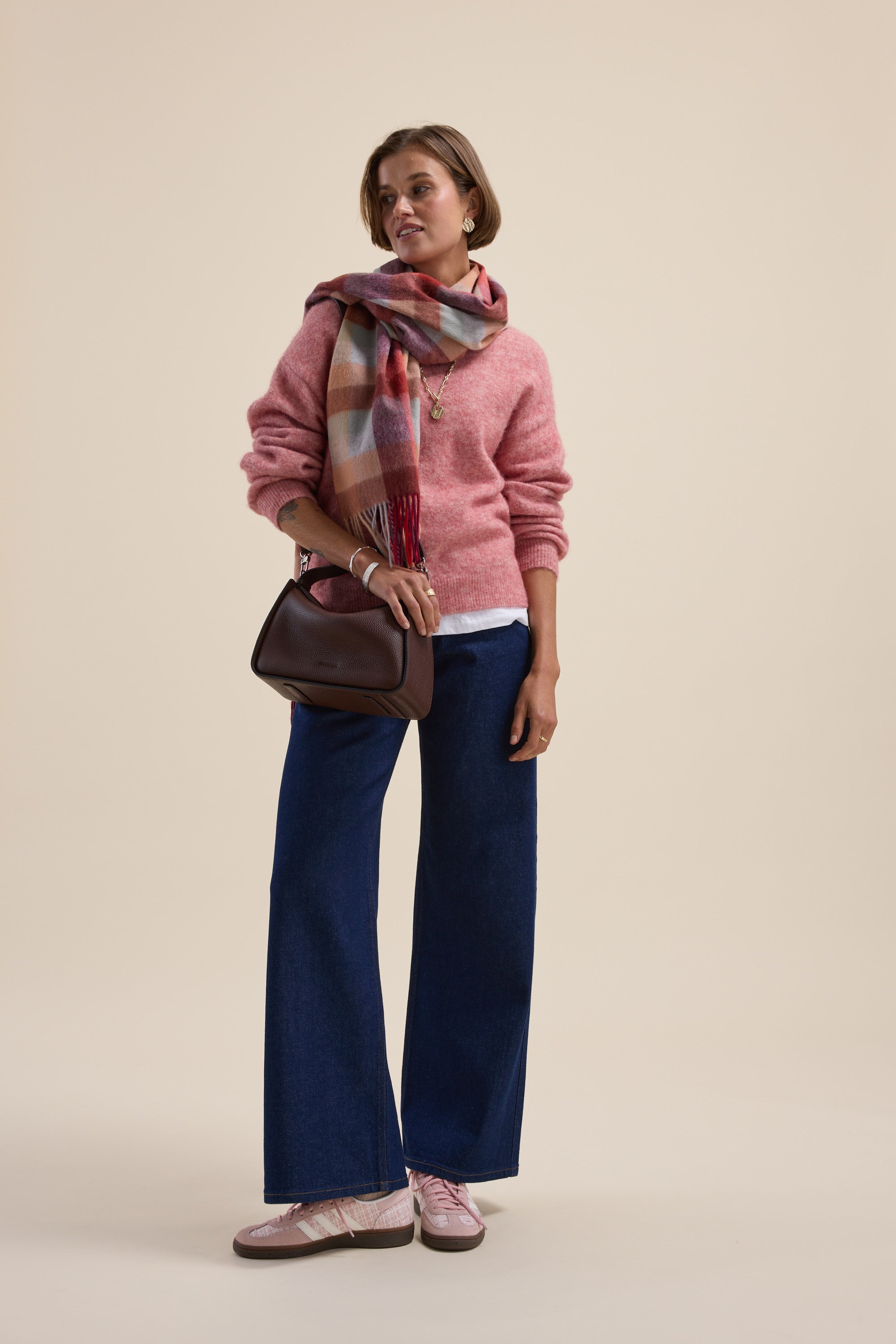 Woman in a pink Hayley Luxe Whisper Crew Neck Sweater by Max, wide blue jeans, scarf, and pink shoes.