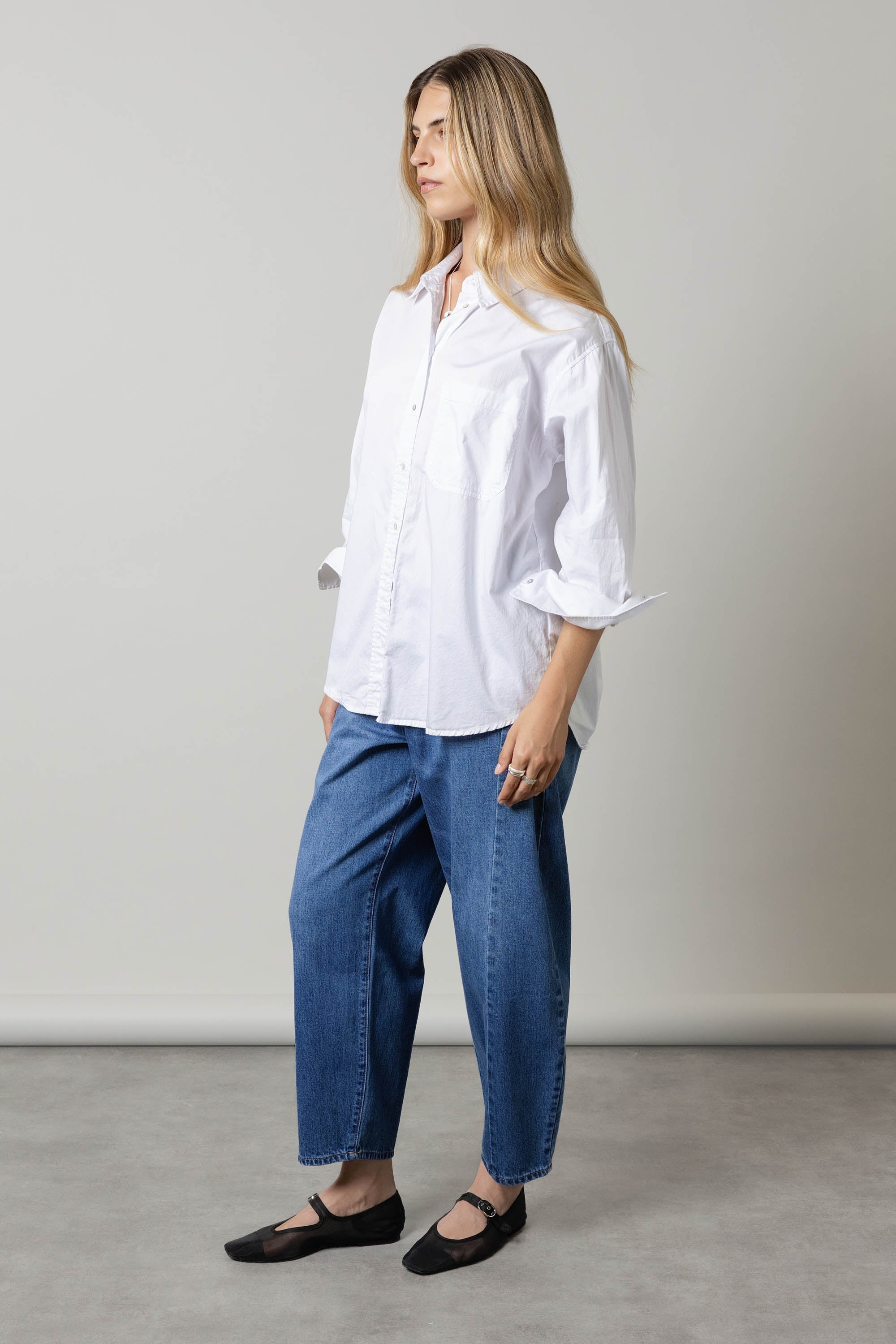 Woman in a white shirt and Max Montreal Barrel Leg Jeans stands sideways against a plain background.