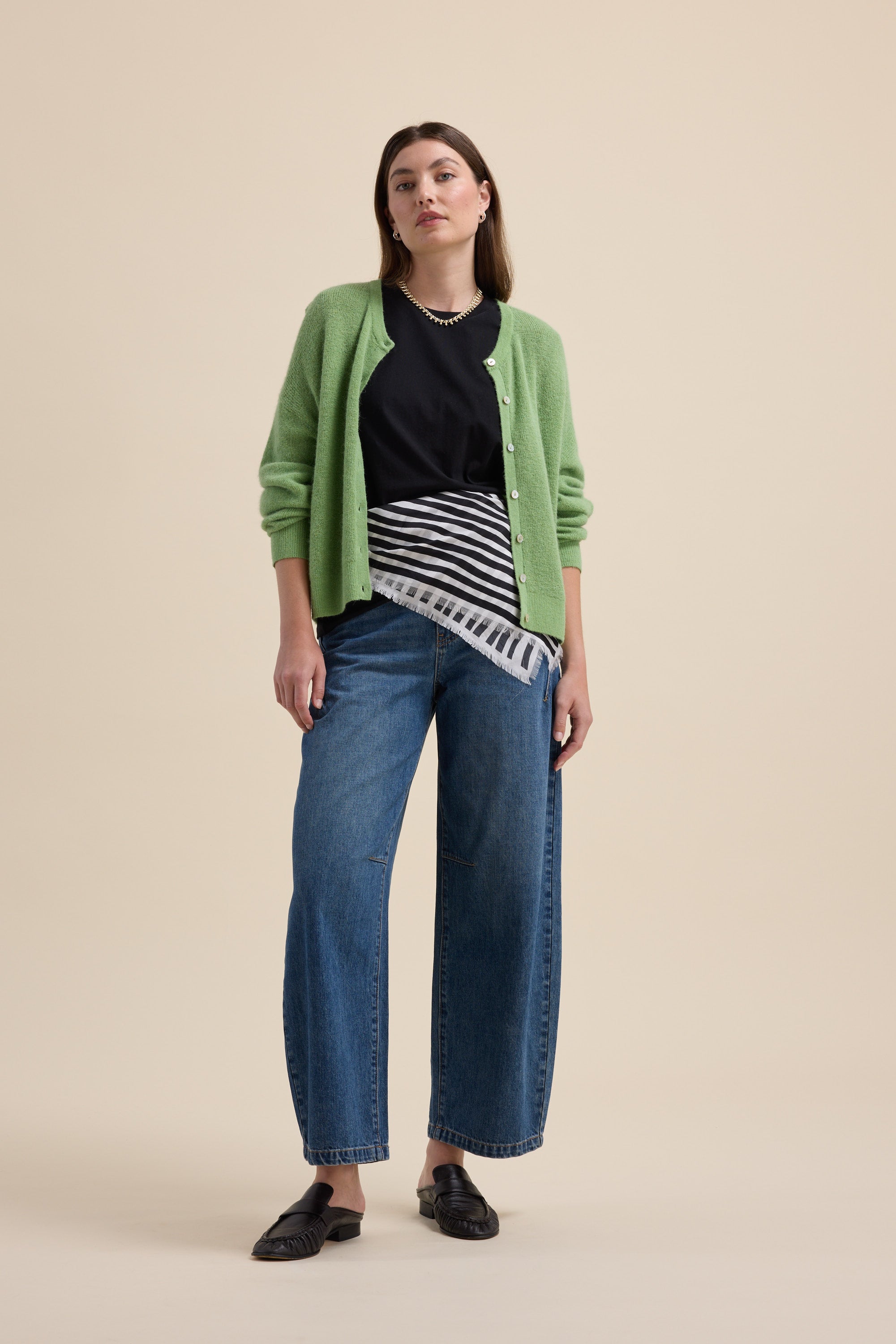 Woman in green cardigan and striped scarf wears Max's The Good Earth Cotton Crew Tee and blue jeans.