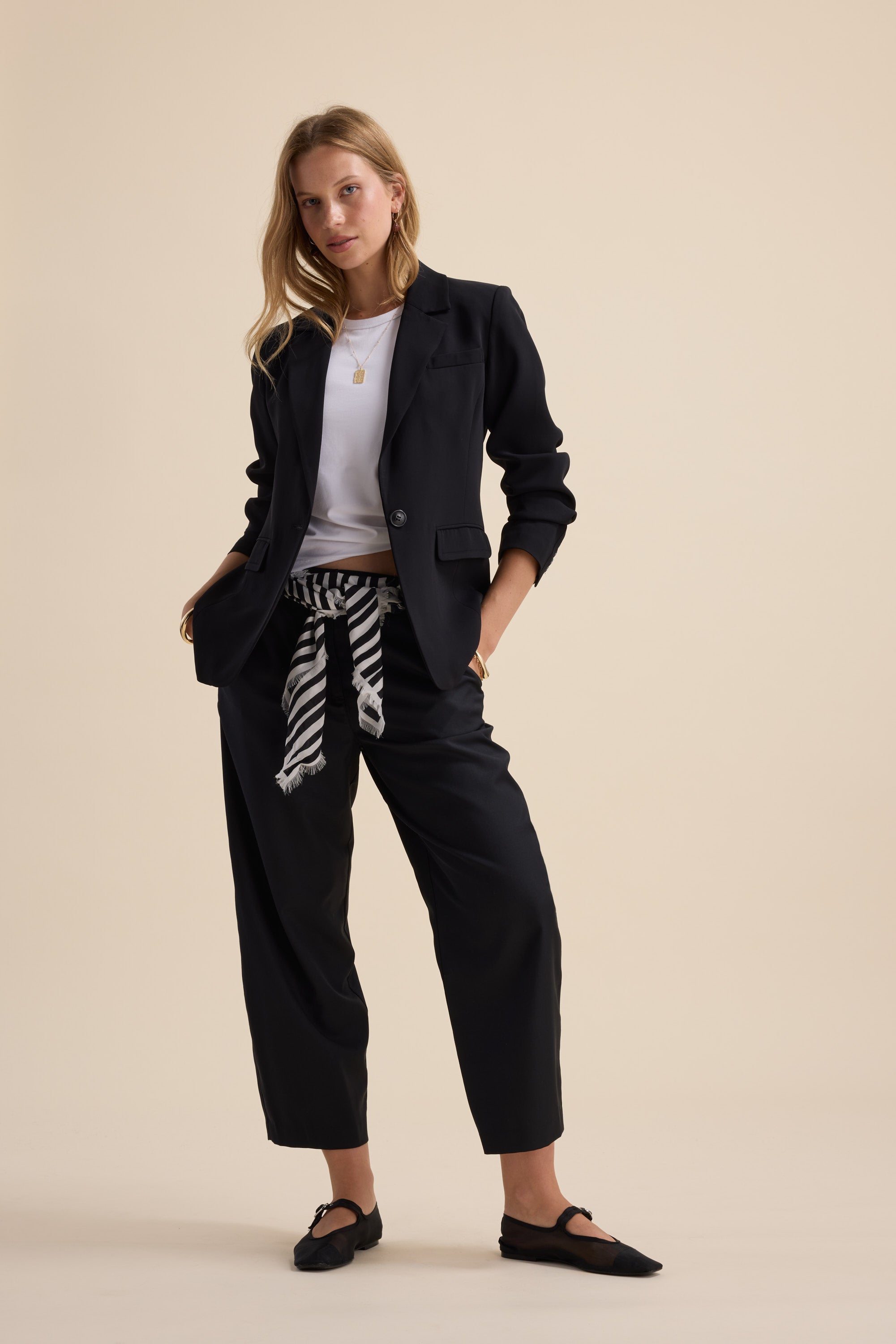 Woman in black Max Wool Blend Barrel Leg Pants stands confidently.
