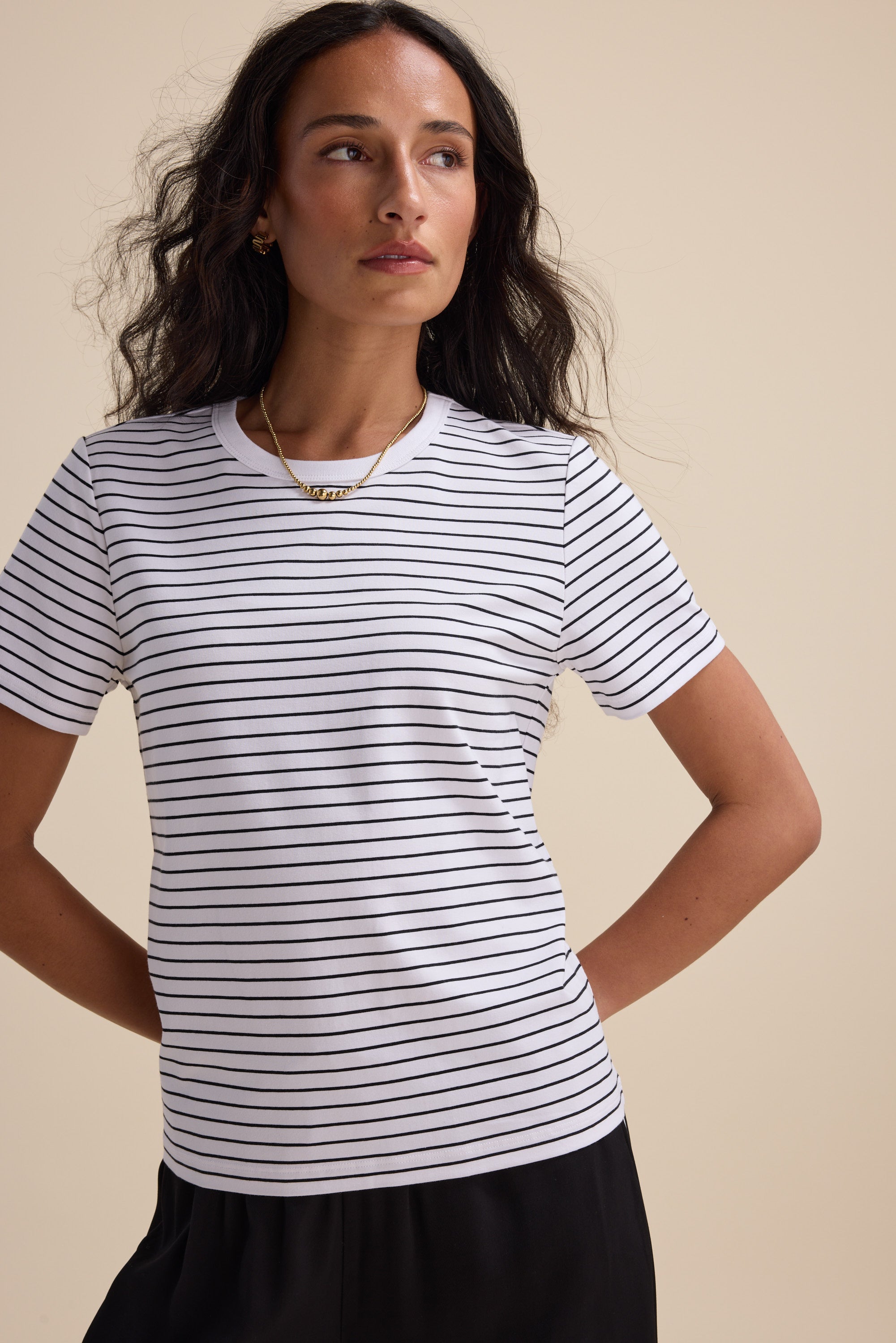 Woman wearing Max's The Perfect Short Sleeve Crew Neck Tee with hands behind her back.